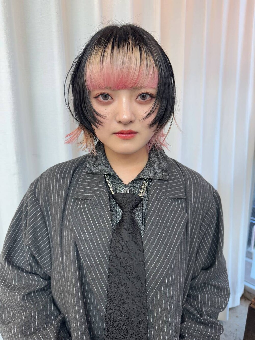 ブラック系のネクタイ、ブラック系のカーディガン/ボレロを着用したレディースの冬コーディネートの2枚目の写真