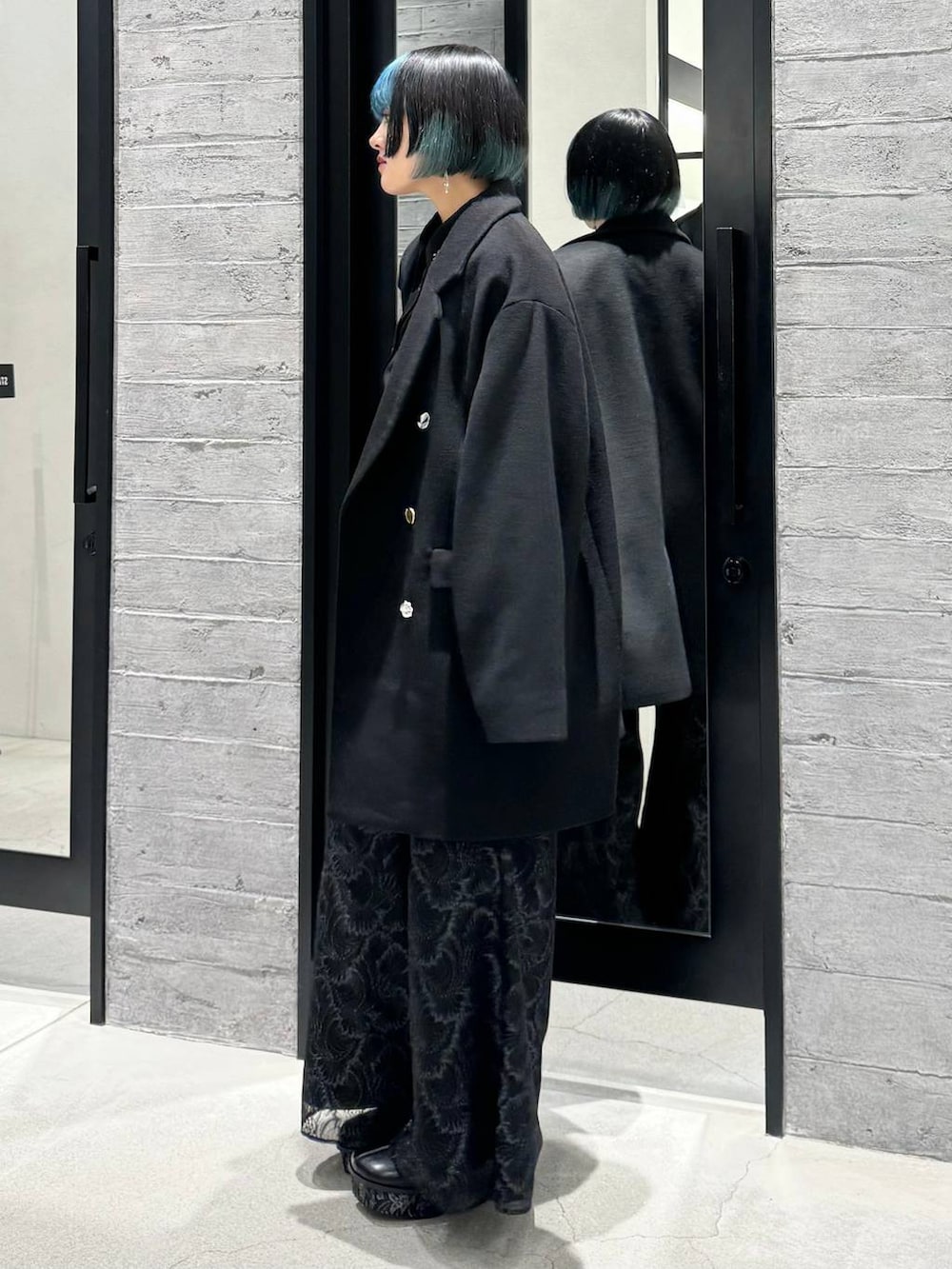 ブラック系のチェスターコート、ブラック系のシャツ/ブラウス、グレー系のブーツを着用したレディースの秋コーディネートの4枚目の写真