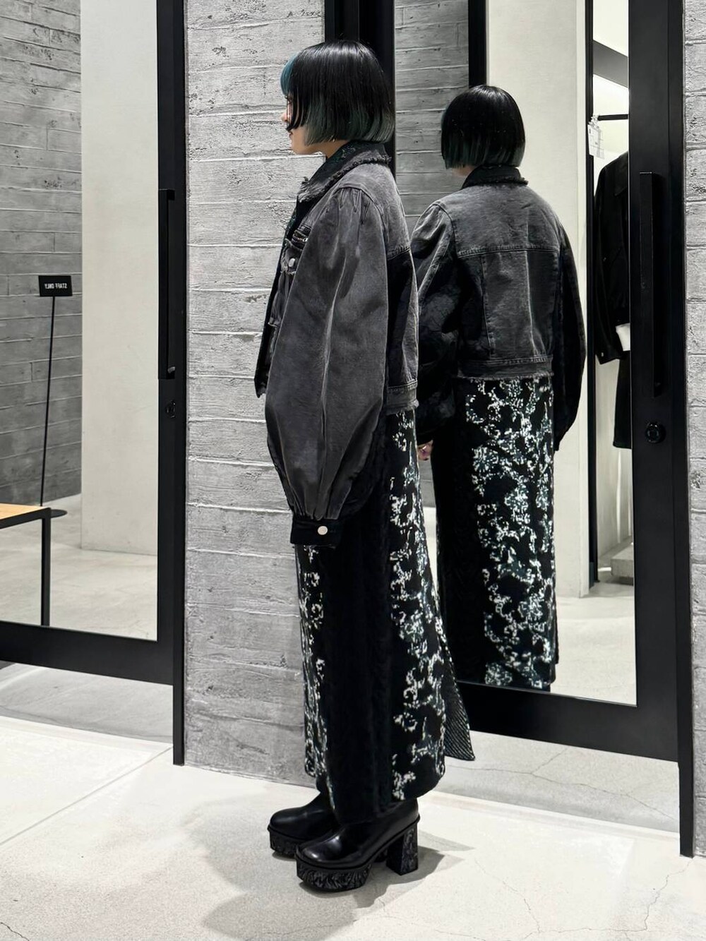 ブラック系のスカート、グリーン系のシャツ/ブラウス、グレー系のブーツを着用したレディースの秋コーディネートの3枚目の写真