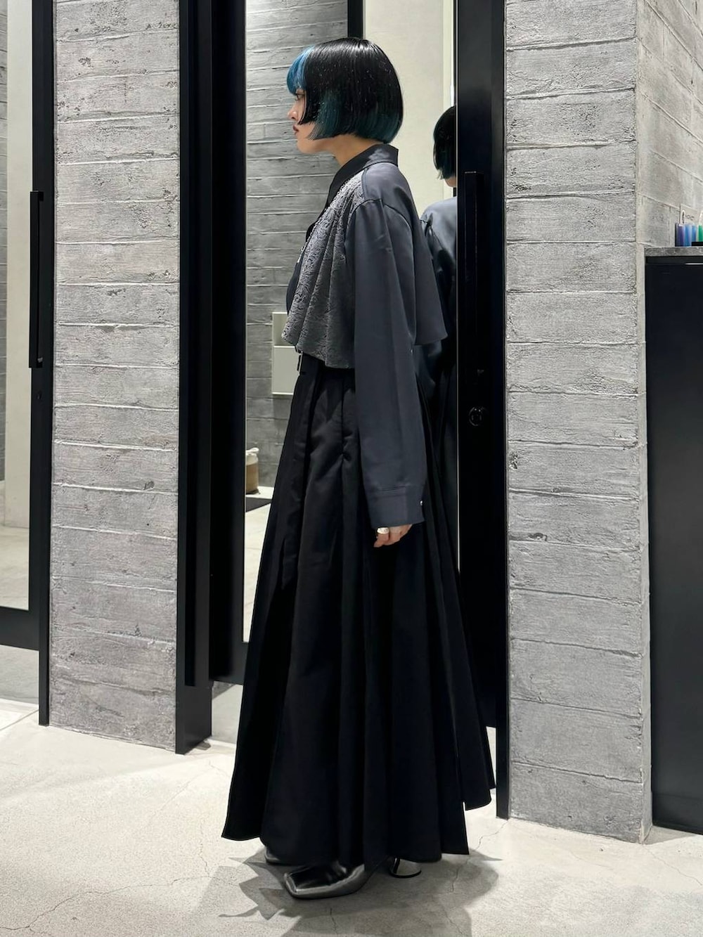 シルバー系のブーツ、グレー系のシャツ/ブラウス、ブラック系のスカートを着用したレディースの秋コーディネートの3枚目の写真