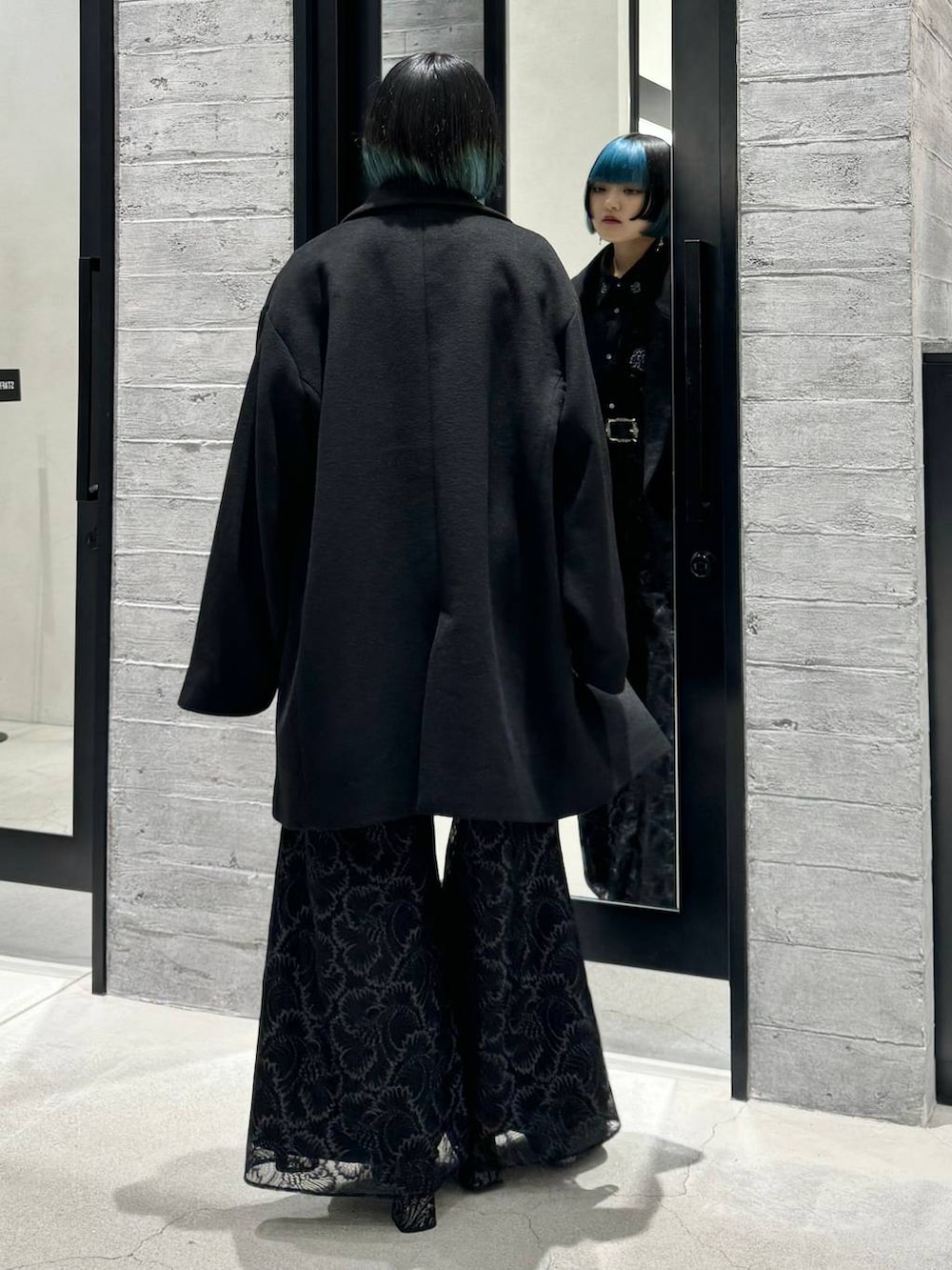 ブラック系のチェスターコート、ブラック系のシャツ/ブラウス、グレー系のブーツを着用したレディースの秋コーディネートの5枚目の写真