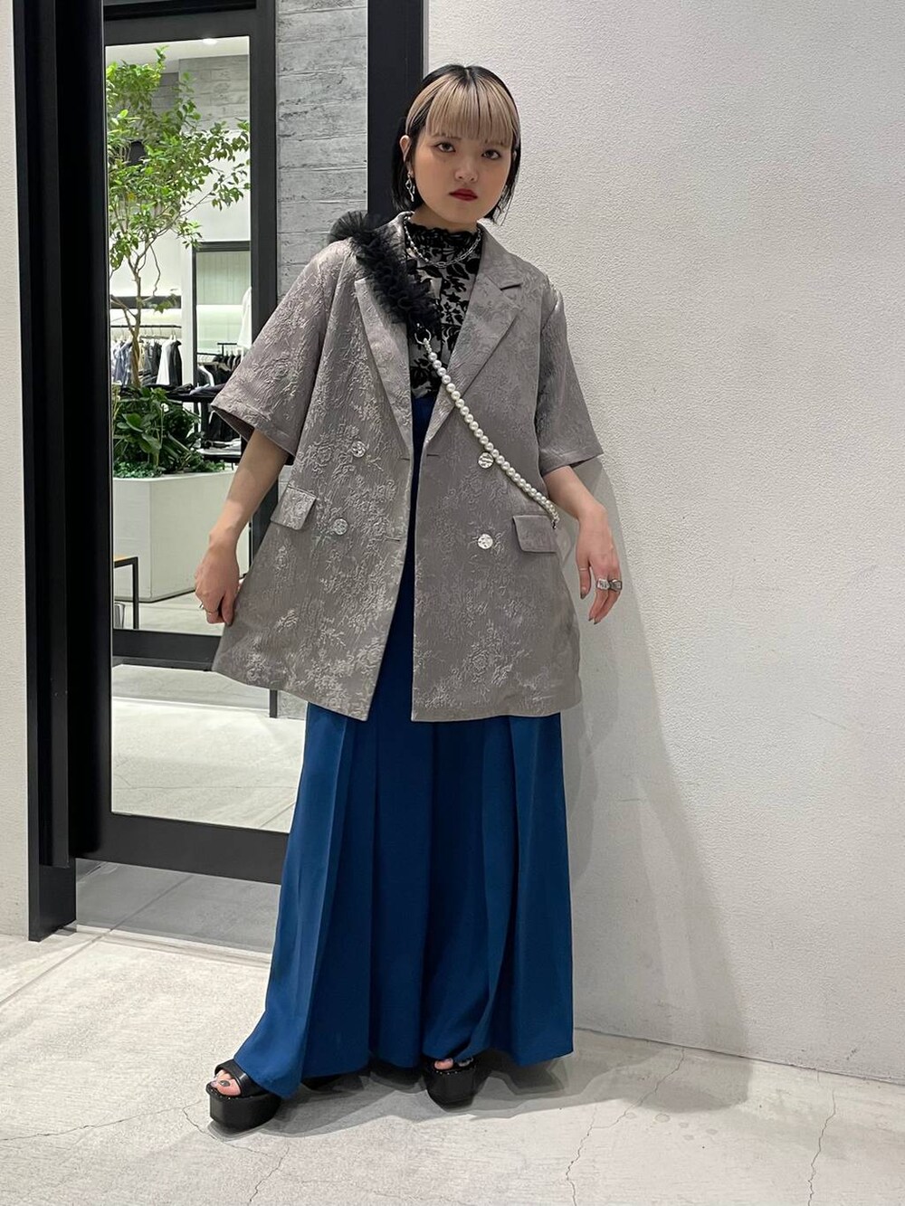 ブラック系のサンダル、ホワイト系のTシャツ/カットソー、ブルー系のその他パンツを着用したレディースの春コーディネートの3枚目の写真