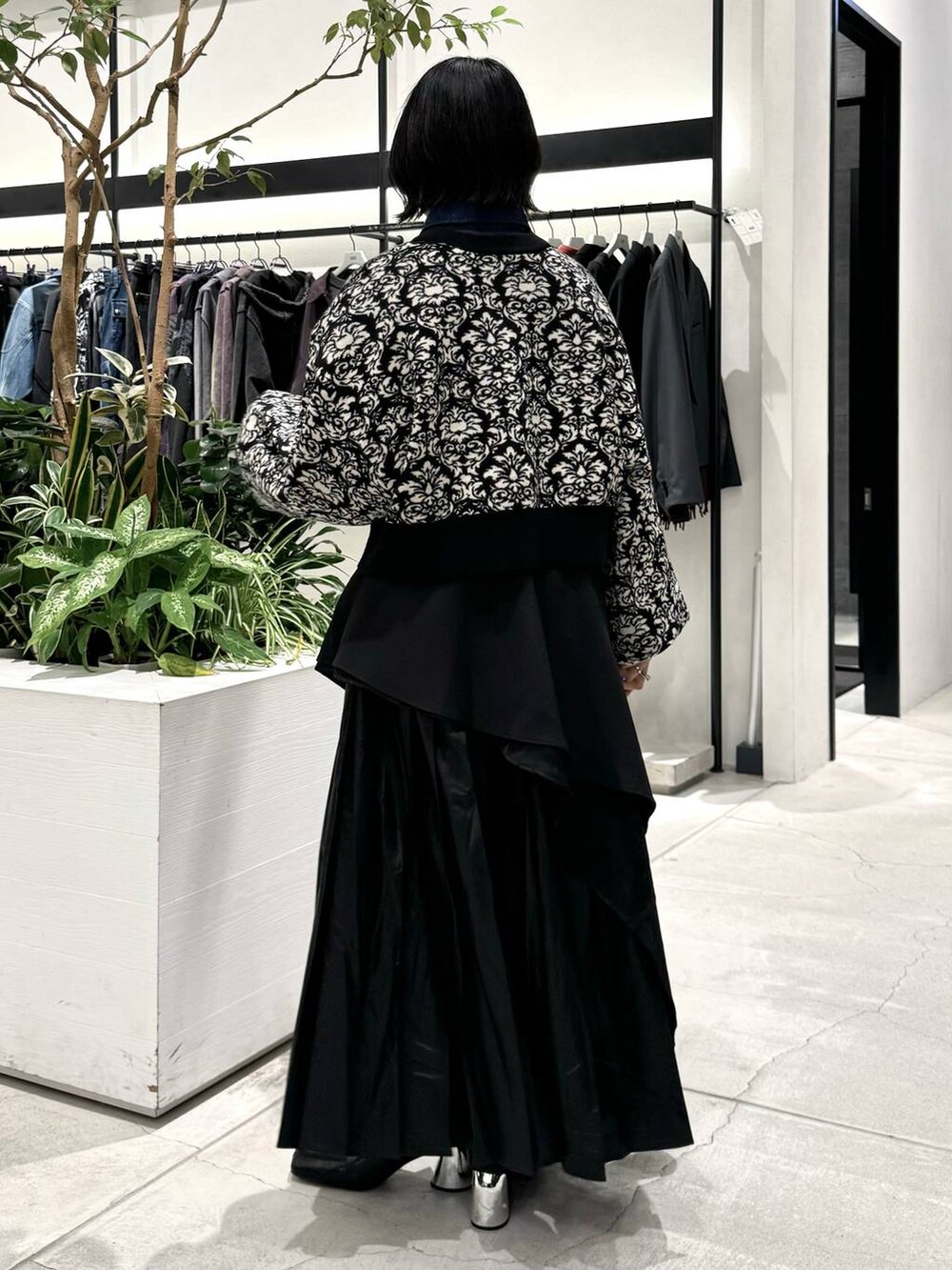 ブラック系のスカート、ブラック系のブーツ、ブラック系のニット/セーターを着用したレディースの秋コーディネートの4枚目の写真