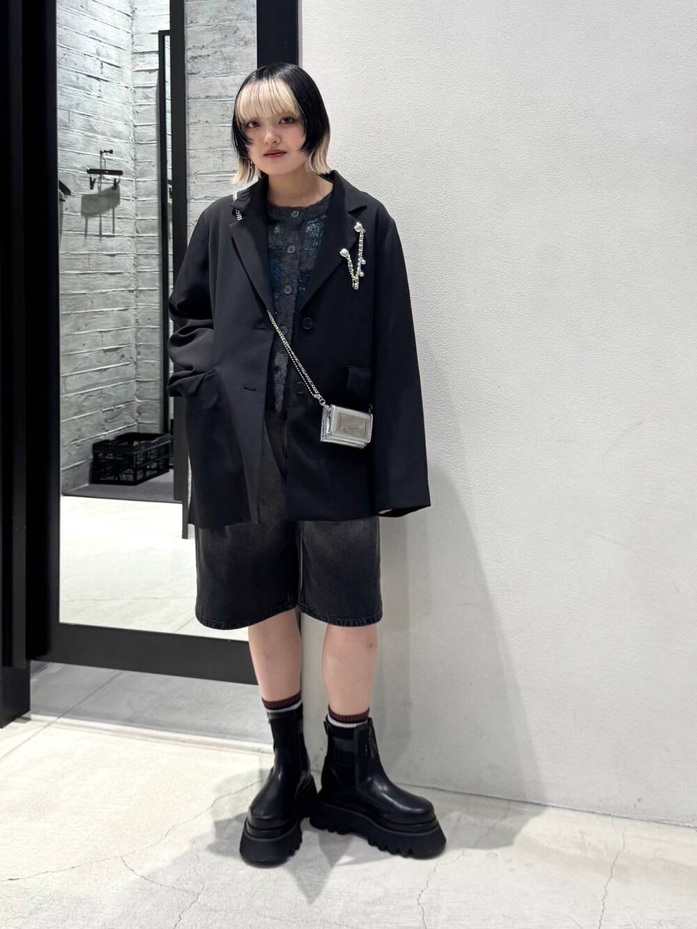 ブラック系のブーツ、グレー系のデニムパンツ、ブラック系のカーディガン/ボレロを着用したレディースの冬コーディネートの2枚目の写真