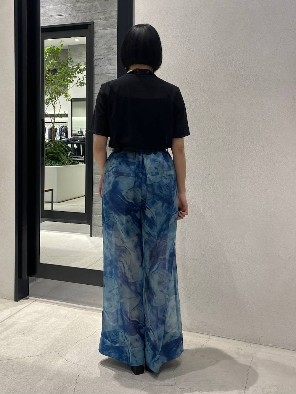 ホワイト系のサンダル、ブルー系のその他パンツ、ブラック系のTシャツ/カットソーを着用したレディースの春コーディネートの4枚目の写真