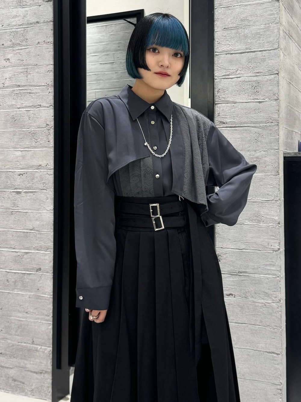 シルバー系のブーツ、グレー系のシャツ/ブラウス、ブラック系のスカートを着用したレディースの秋コーディネートの2枚目の写真