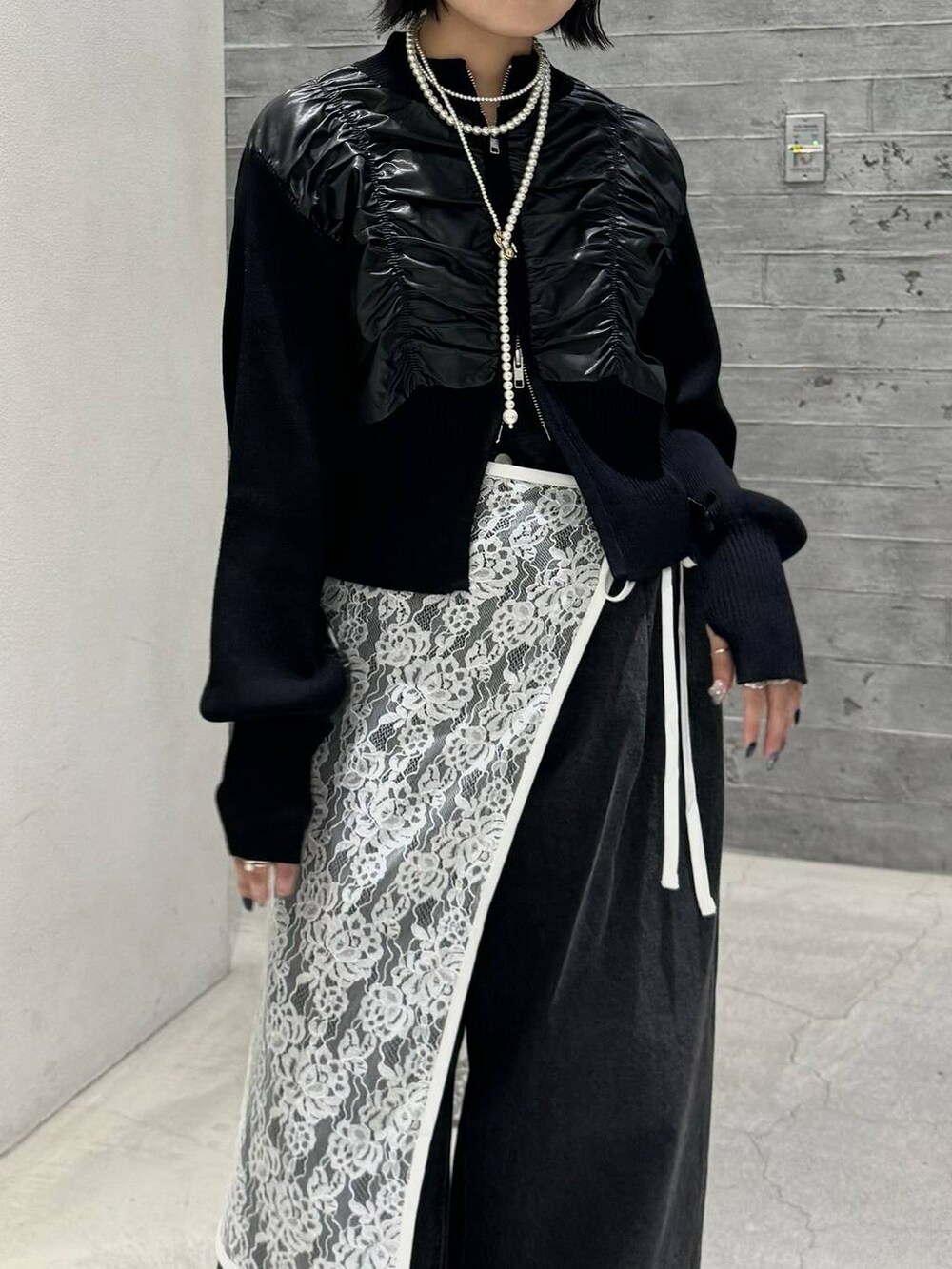 ブラック系のブーツ、ブラック系のデニムパンツ、ブラック系のニット/セーターを着用したレディースの秋コーディネートの2枚目の写真