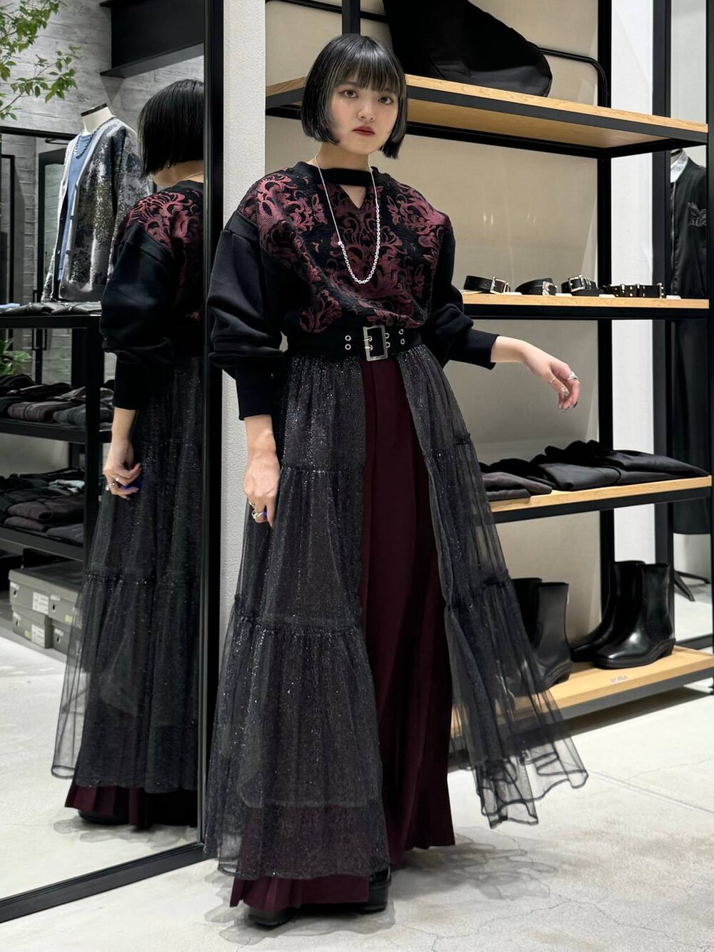 ブラック系のブーツ、レッド系のスウェット、レッド系のその他パンツを着用したレディースの秋コーディネートの3枚目の写真