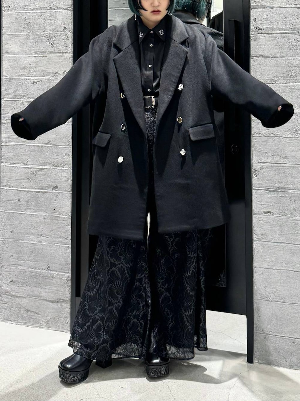 ブラック系のチェスターコート、ブラック系のシャツ/ブラウス、グレー系のブーツを着用したレディースの秋コーディネートの3枚目の写真