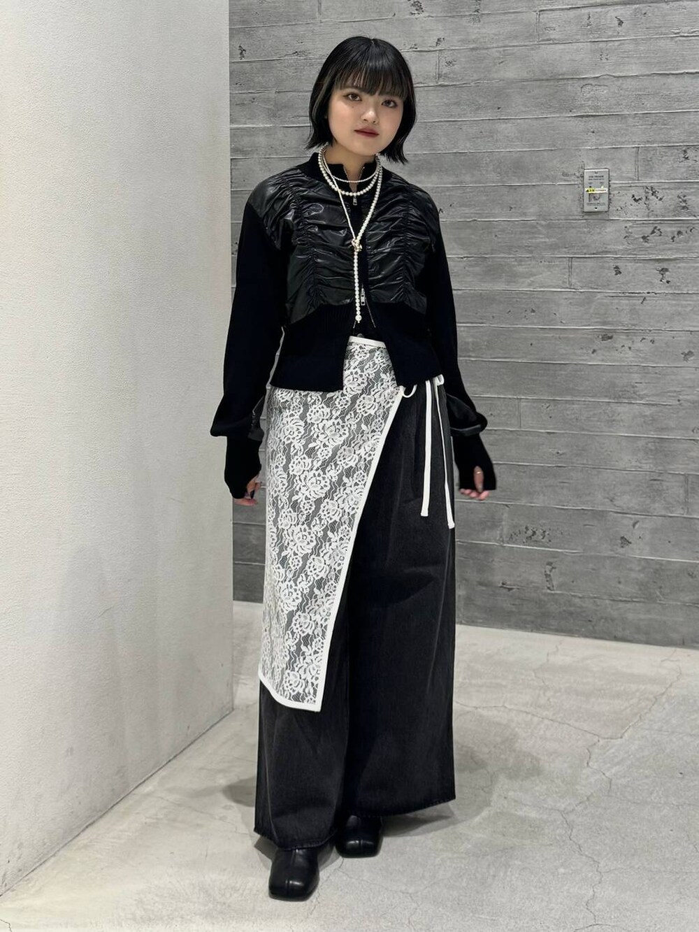 ブラック系のブーツ、ブラック系のデニムパンツ、ブラック系のニット/セーターを着用したレディースの秋コーディネートの5枚目の写真