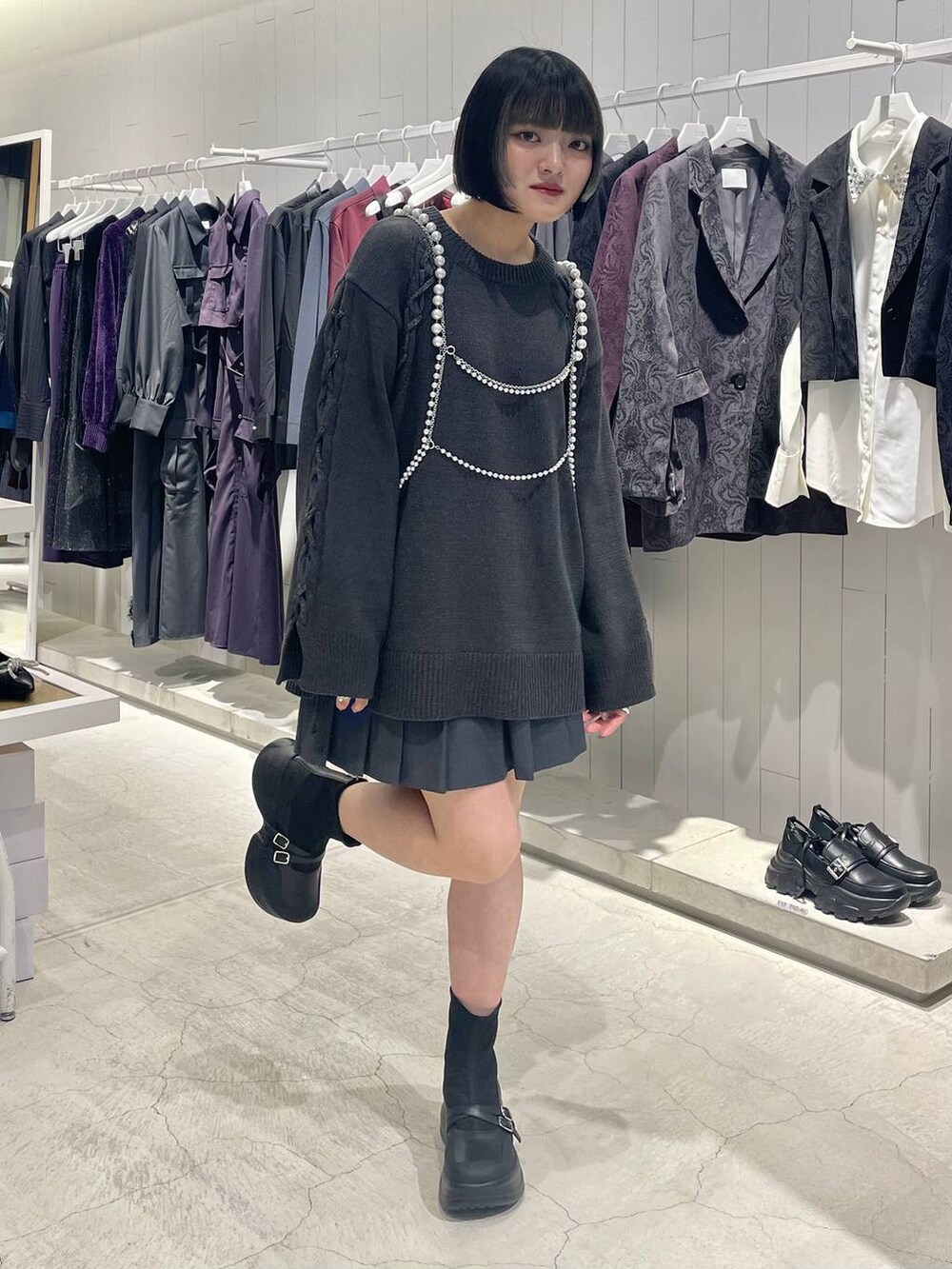 グレー系のテーラードジャケット、ブラック系のブーツ、グレー系のニット/セーターを着用したレディースの秋コーディネートの6枚目の写真