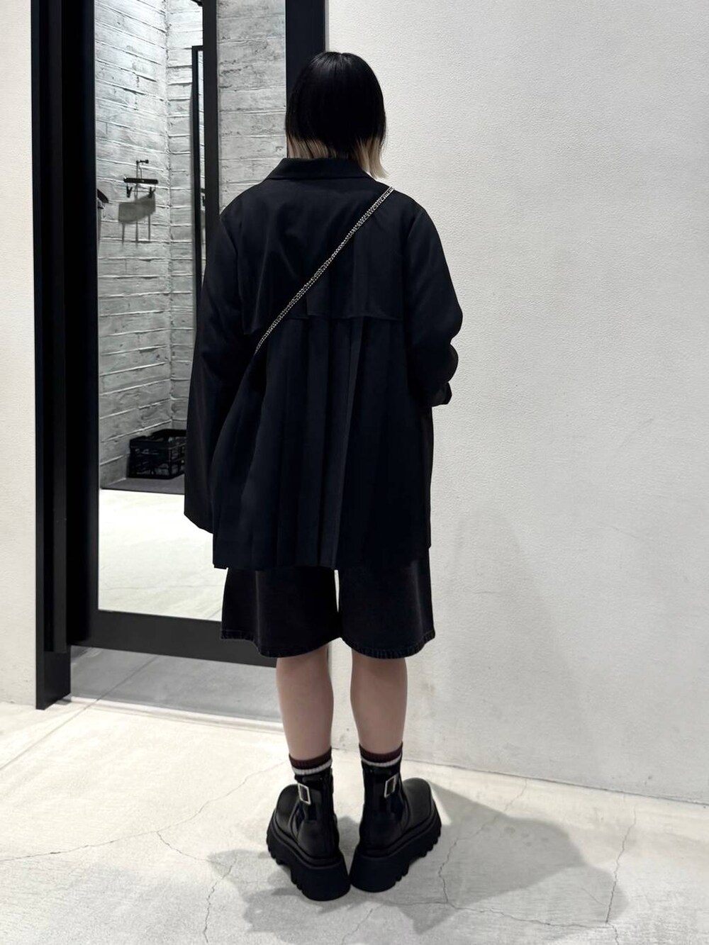 ブラック系のブーツ、グレー系のデニムパンツ、ブラック系のカーディガン/ボレロを着用したレディースの冬コーディネートの3枚目の写真