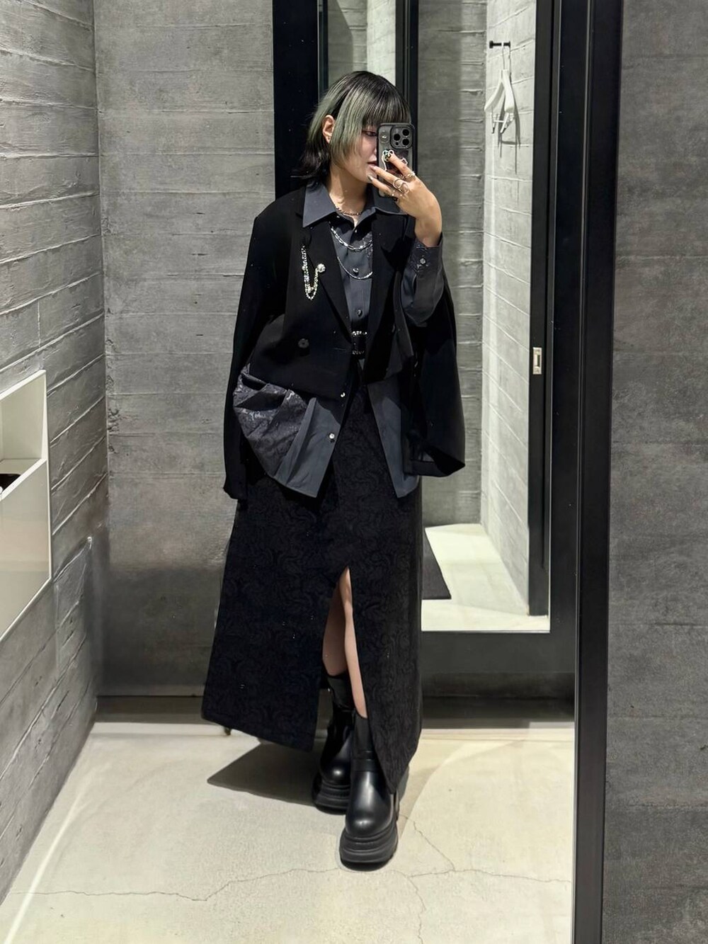 ブラック系のブーツ、ブラック系のテーラードジャケット、ブラック系のスカートを着用したレディースの秋コーディネートの4枚目の写真