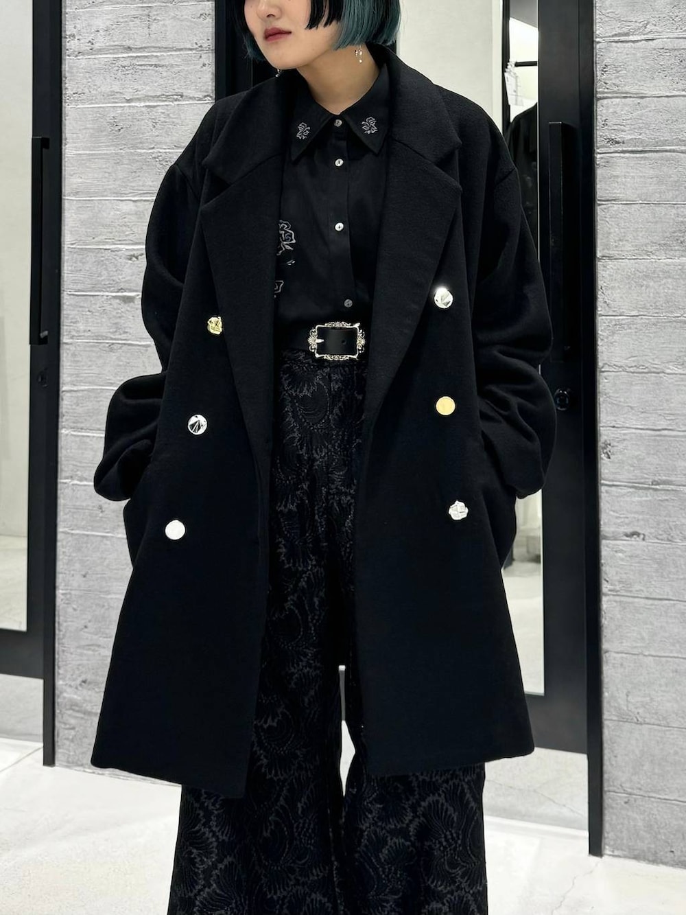 ブラック系のチェスターコート、ブラック系のシャツ/ブラウス、グレー系のブーツを着用したレディースの秋コーディネートの2枚目の写真