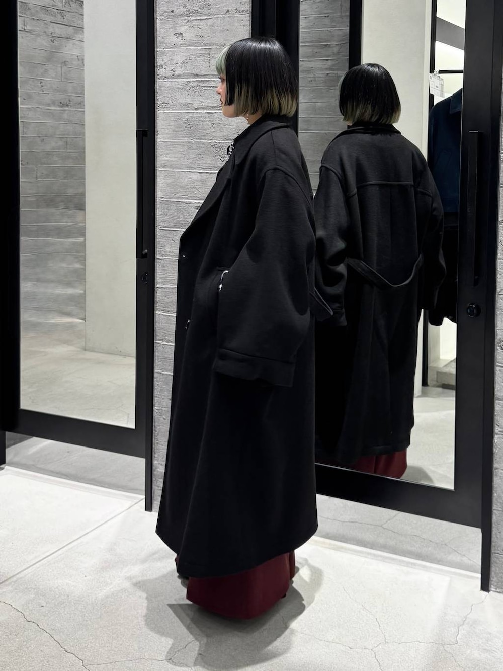 ブラック系のトレンチコート、ブラック系のシャツ/ブラウス、ブラック系のカーディガン/ボレロを着用したレディースの冬コーディネートの6枚目の写真