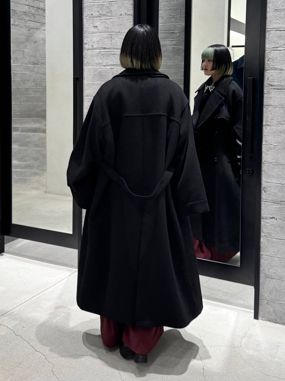 ブラック系のトレンチコート、ブラック系のシャツ/ブラウス、ブラック系のカーディガン/ボレロを着用したレディースの冬コーディネートの5枚目の写真