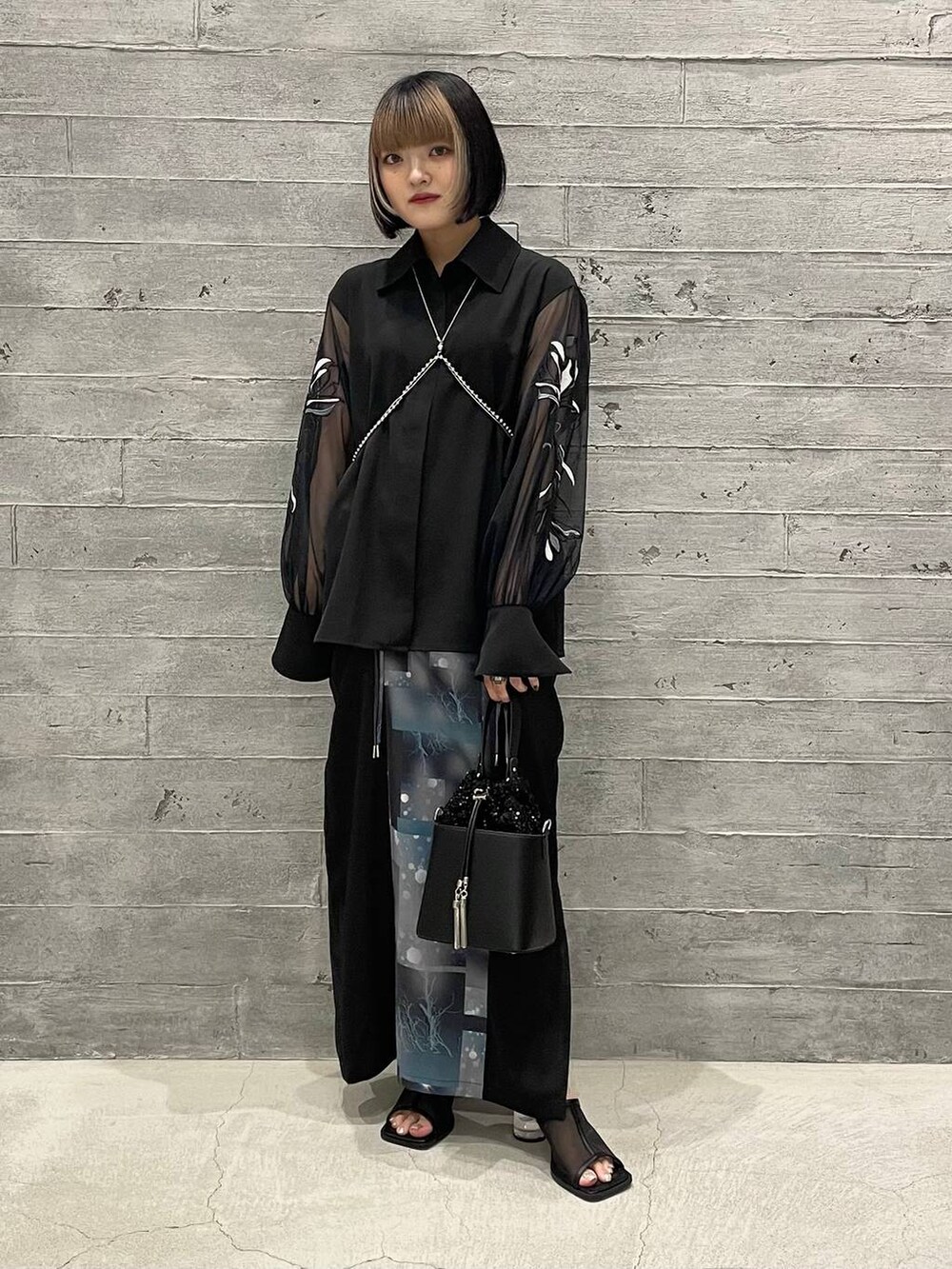 ブラック系のサンダル、ブラック系のショルダーバッグ、ブラック系のシャツ/ブラウスを着用したレディースの夏コーディネートの3枚目の写真