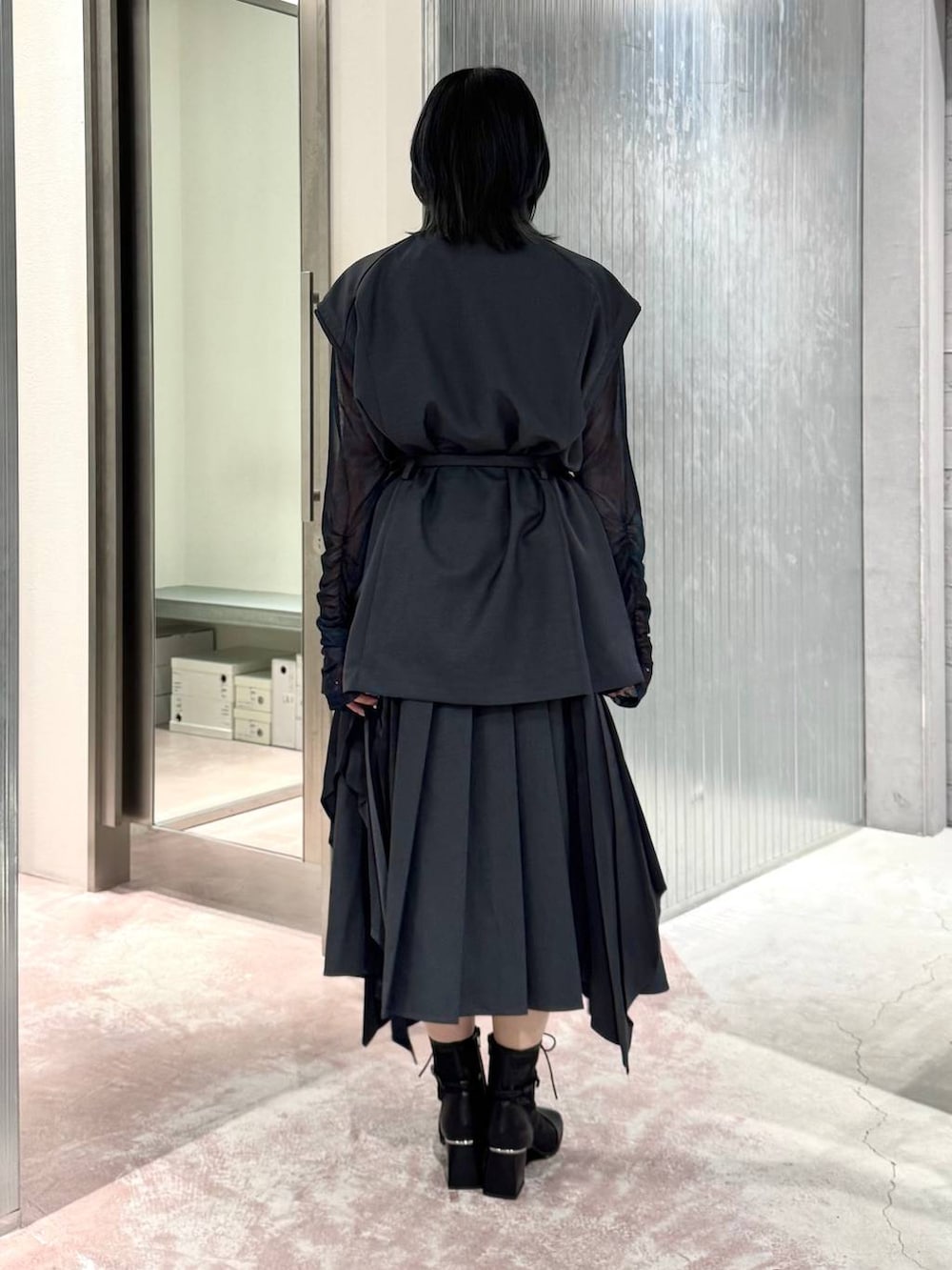 グレー系のスカート、ブラック系のブーツ、ブルー系のTシャツ/カットソーを着用したレディースの夏コーディネートの6枚目の写真