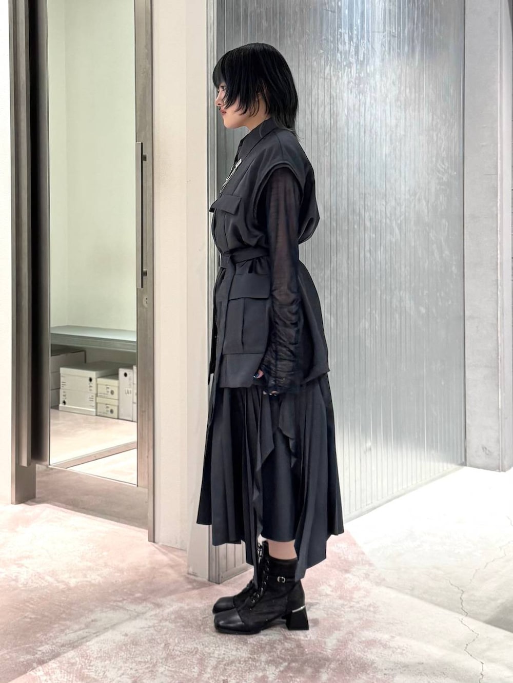 グレー系のスカート、ブラック系のブーツ、ブルー系のTシャツ/カットソーを着用したレディースの夏コーディネートの5枚目の写真