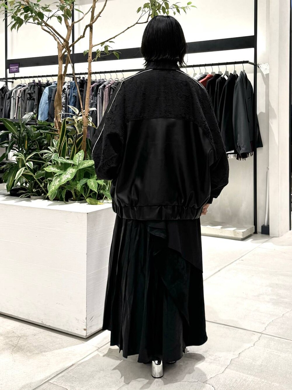 ブラック系のスカート、ブラック系のブーツ、ブルー系のシャツ/ブラウスを着用したレディースの秋コーディネートの3枚目の写真