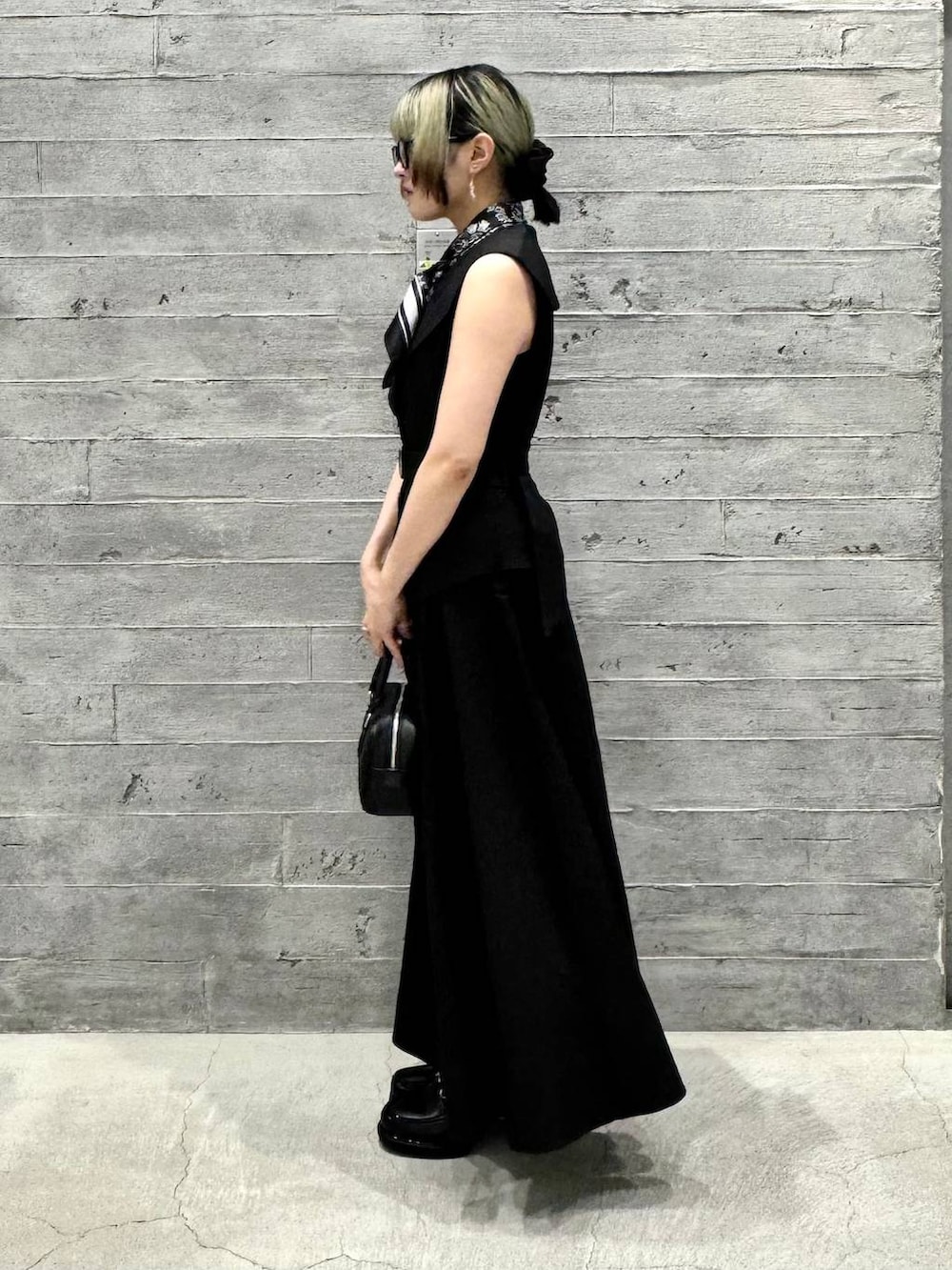 ブラック系のワンピース、ブラック系のローファー、ブラック系のボストンバッグを着用したレディースの夏コーディネートの4枚目の写真