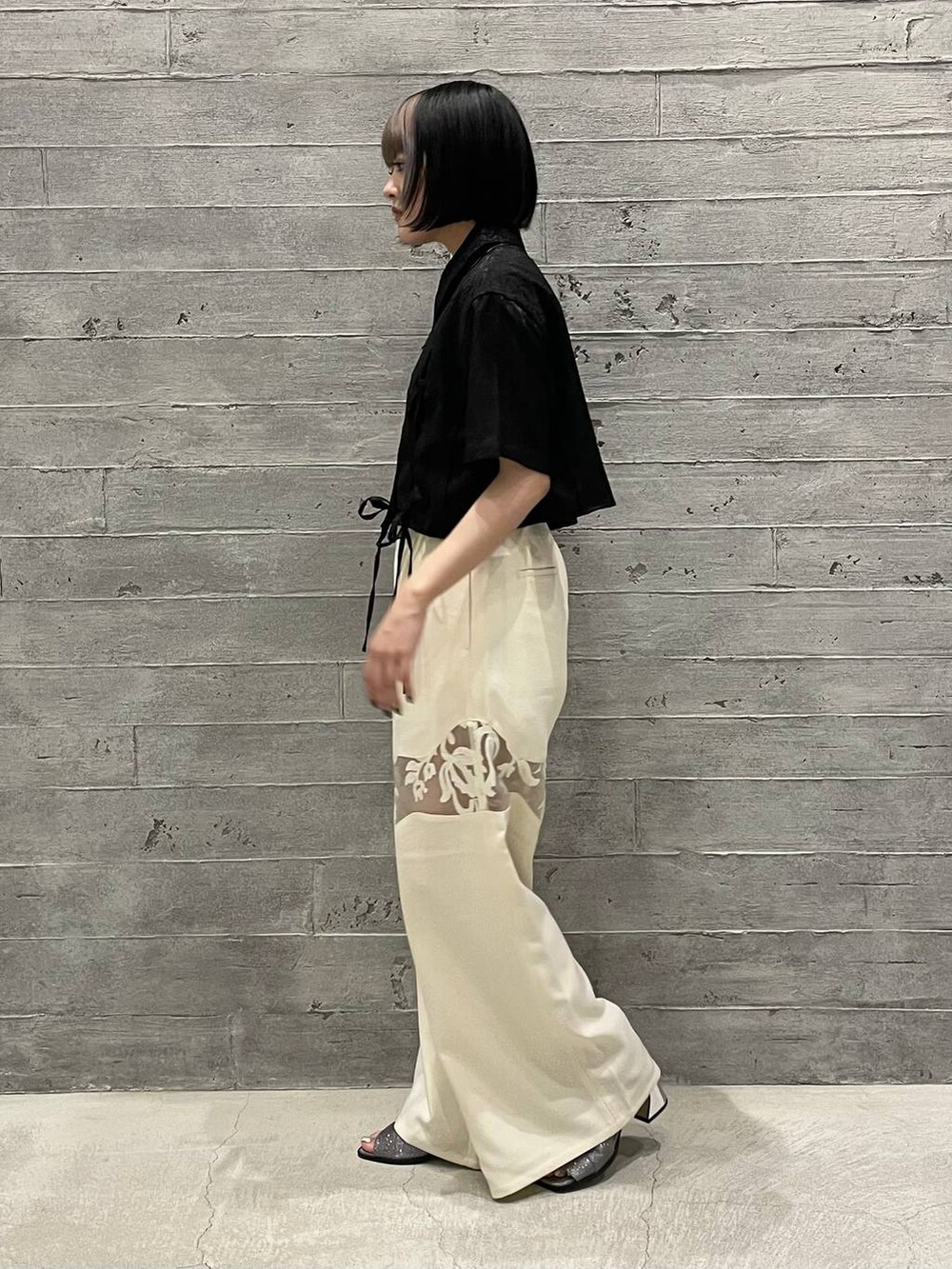 ホワイト系のその他パンツ、ブラック系のシャツ/ブラウス、シルバー系のサンダルを着用したレディースの夏コーディネートの2枚目の写真