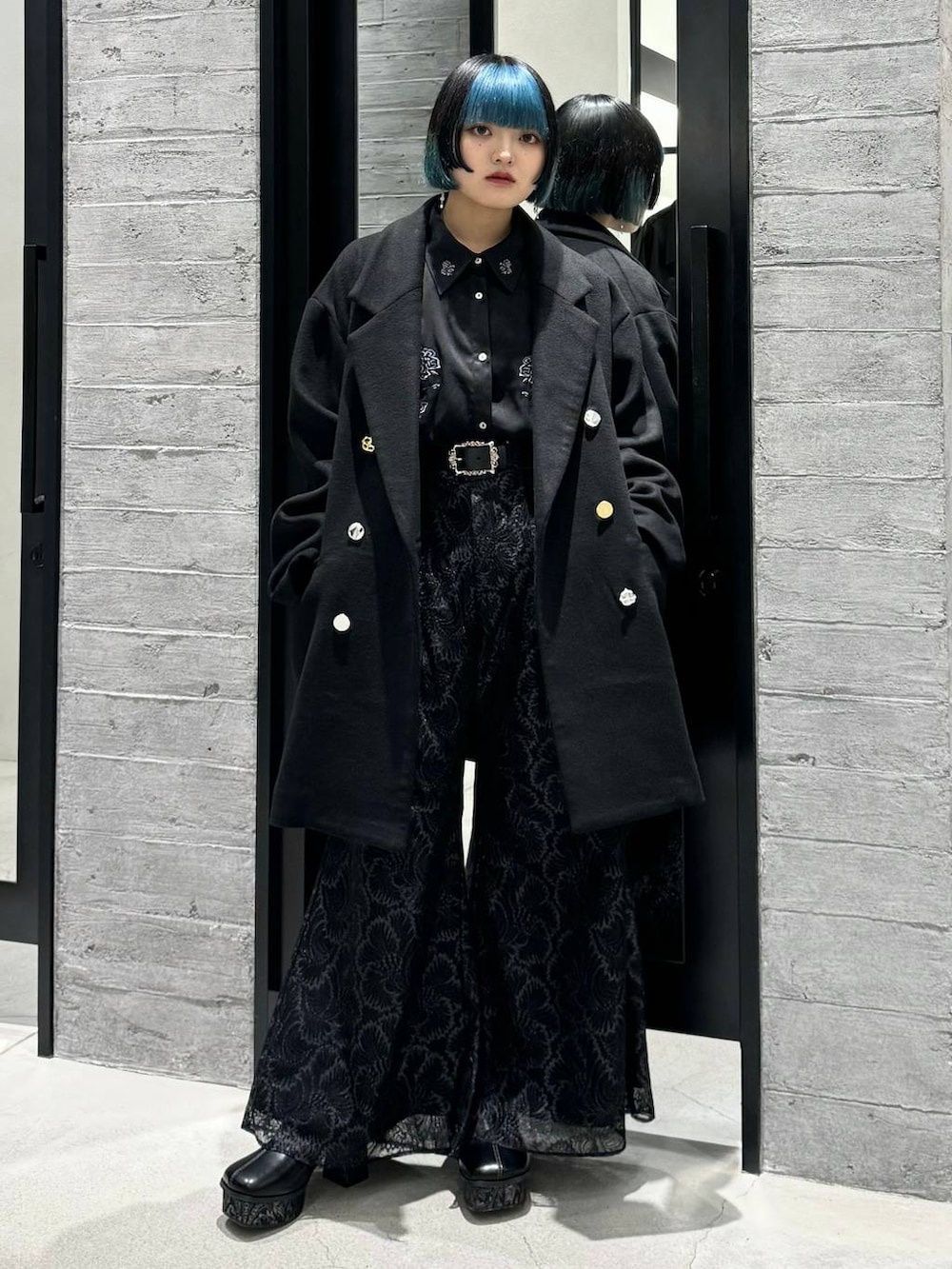 ブラック系のチェスターコート、ブラック系のシャツ/ブラウス、グレー系のブーツを着用したレディースの秋コーディネートの6枚目の写真