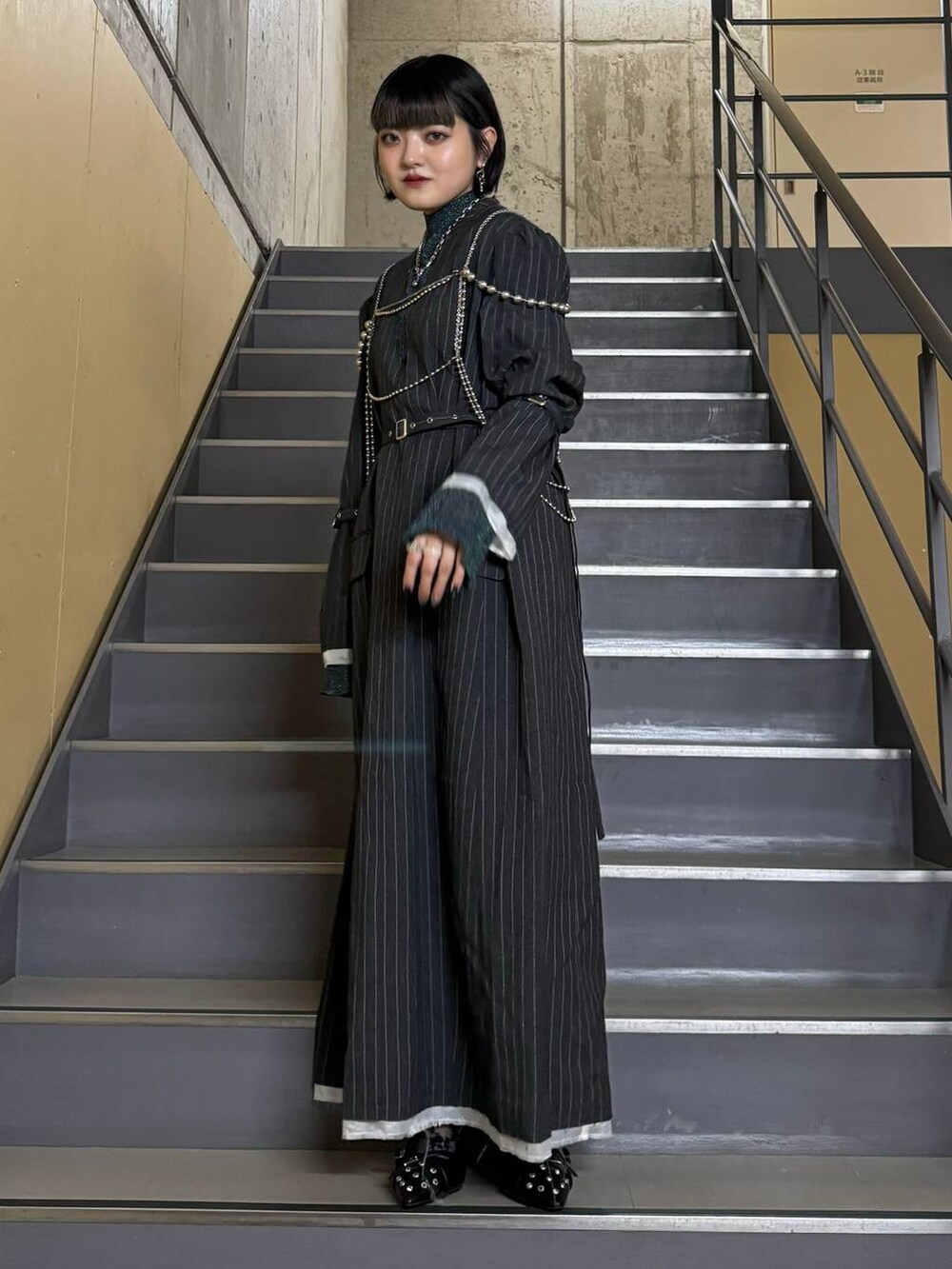 ブラック系のパンプス、ブルー系のニット/セーター、グレー系のワンピースを着用したレディースの秋コーディネートの2枚目の写真