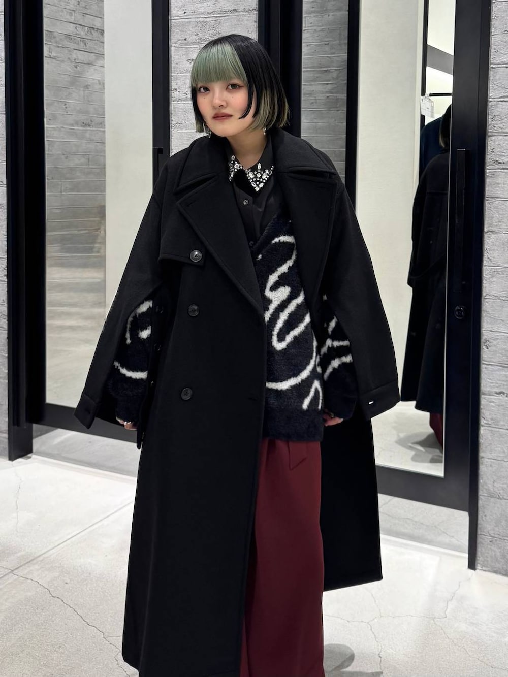 ブラック系のトレンチコート、ブラック系のシャツ/ブラウス、ブラック系のカーディガン/ボレロを着用したレディースの冬コーディネートの2枚目の写真