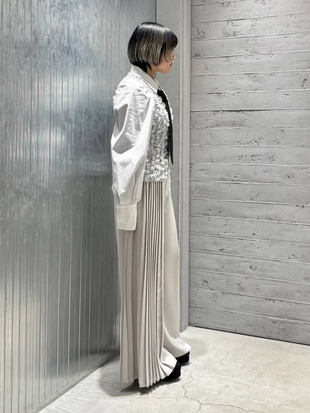 ブラック系のネクタイ、ブラック系のパンプス、ホワイト系のシャツ/ブラウスを着用したレディースの冬コーディネートの5枚目の写真