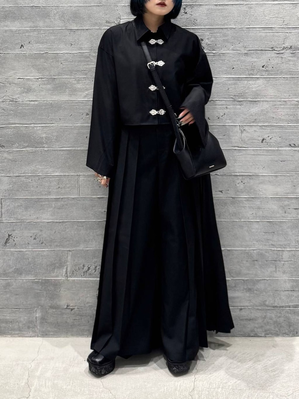 ブラック系のシャツ/ブラウス、グレー系のブーツ、ブラック系のショルダーバッグを着用したレディースの秋コーディネートの2枚目の写真