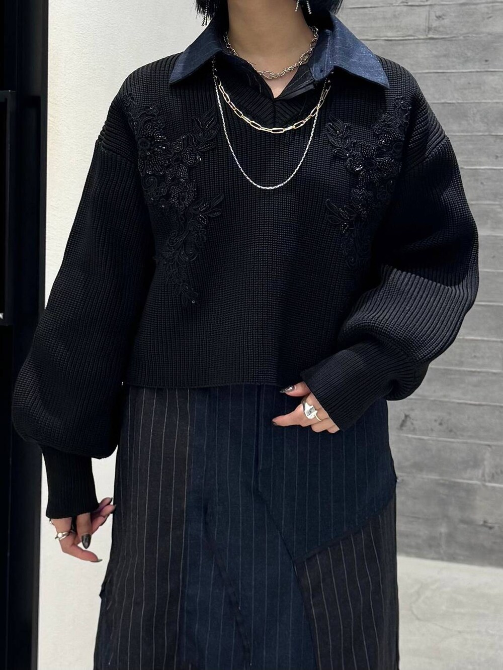 グレー系のブーツ、ブラック系のニット/セーター、ブルー系のスカートを着用したレディースの秋コーディネートの6枚目の写真