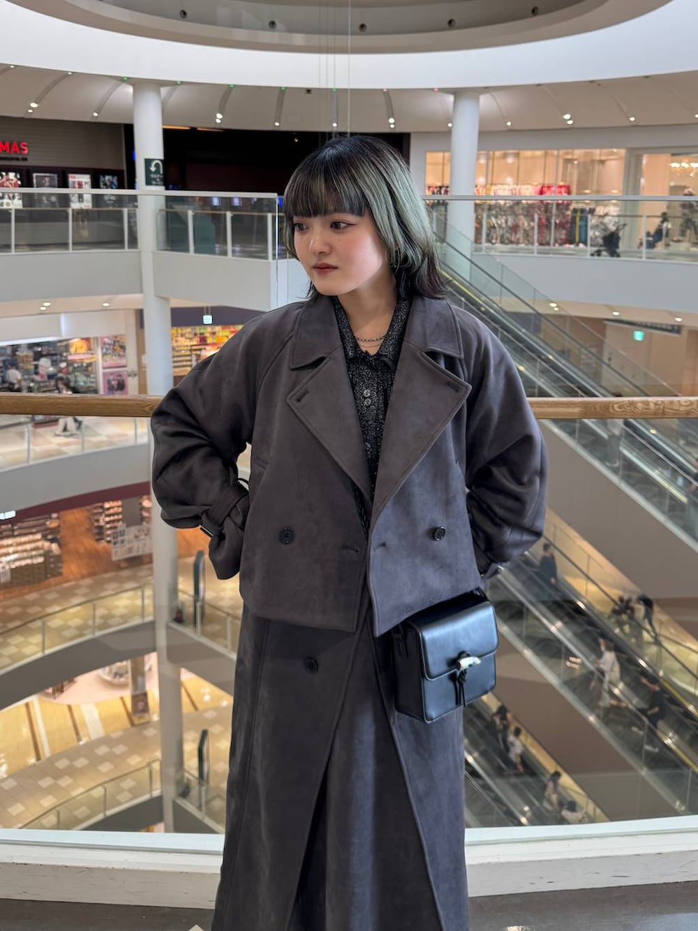 シルバー系のブーツ、ブラック系のショルダーバッグ、ブラック系のカーディガン/ボレロを着用したレディースの秋コーディネートの2枚目の写真