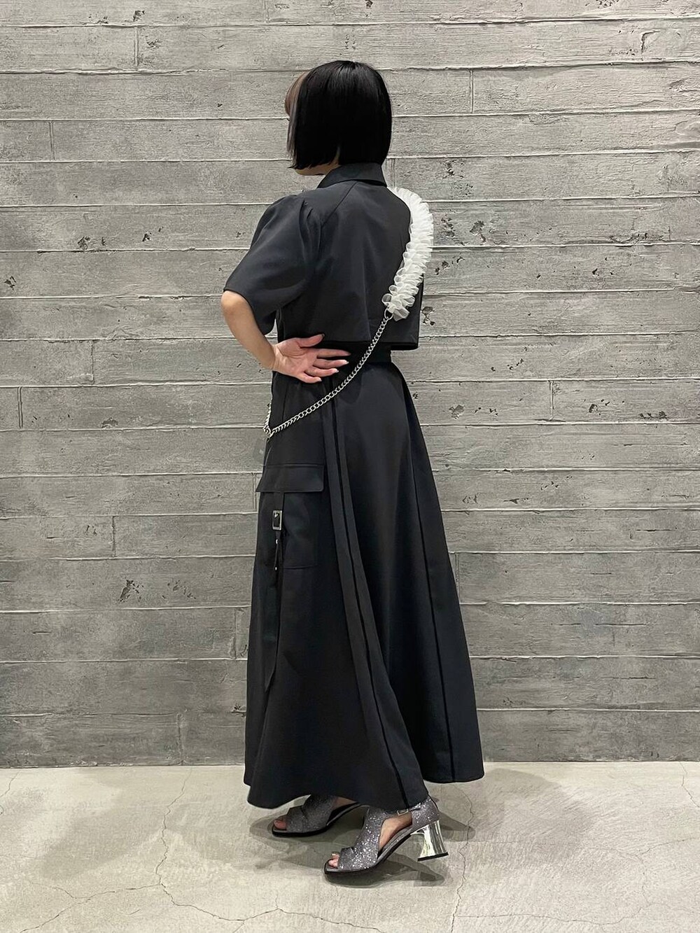 シルバー系のサンダル、グレー系のワンピース、ホワイト系のスマホグッズを着用したレディースの夏コーディネートの3枚目の写真