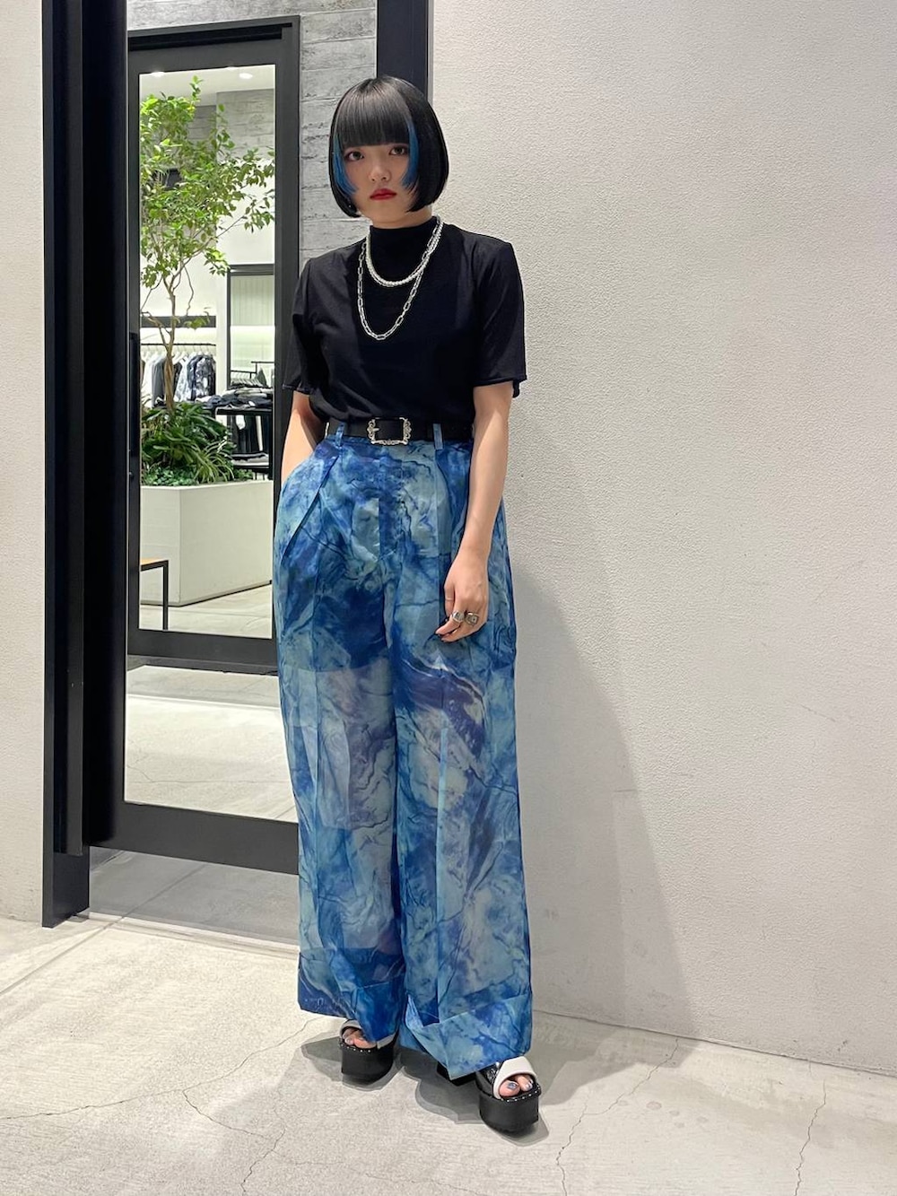 ホワイト系のサンダル、ブルー系のその他パンツ、ブラック系のTシャツ/カットソーを着用したレディースの春コーディネートの2枚目の写真