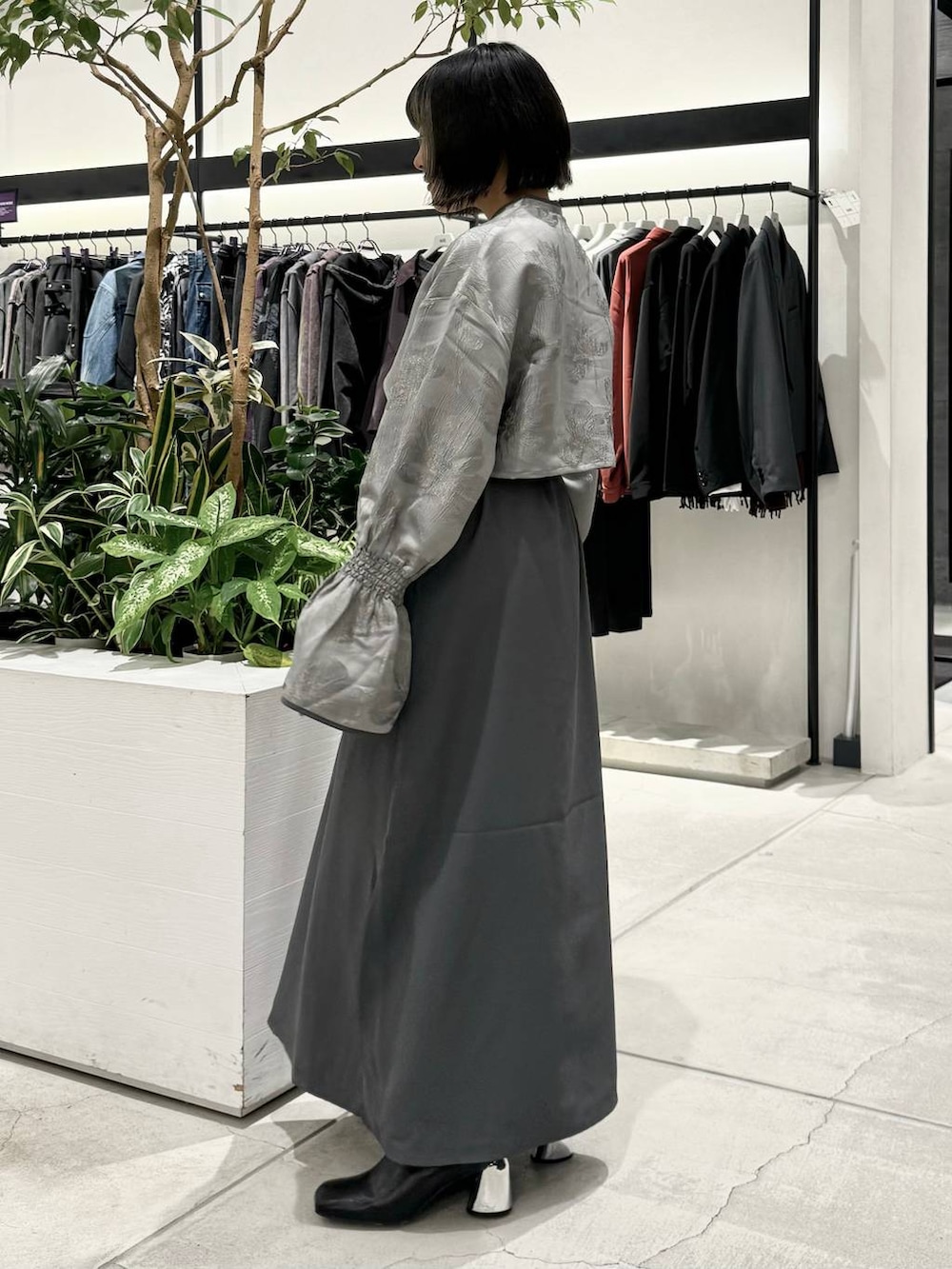 ブラック系のブーツ、グレー系のワンピース、ブラック系のベルトを着用したレディースの秋コーディネートの2枚目の写真