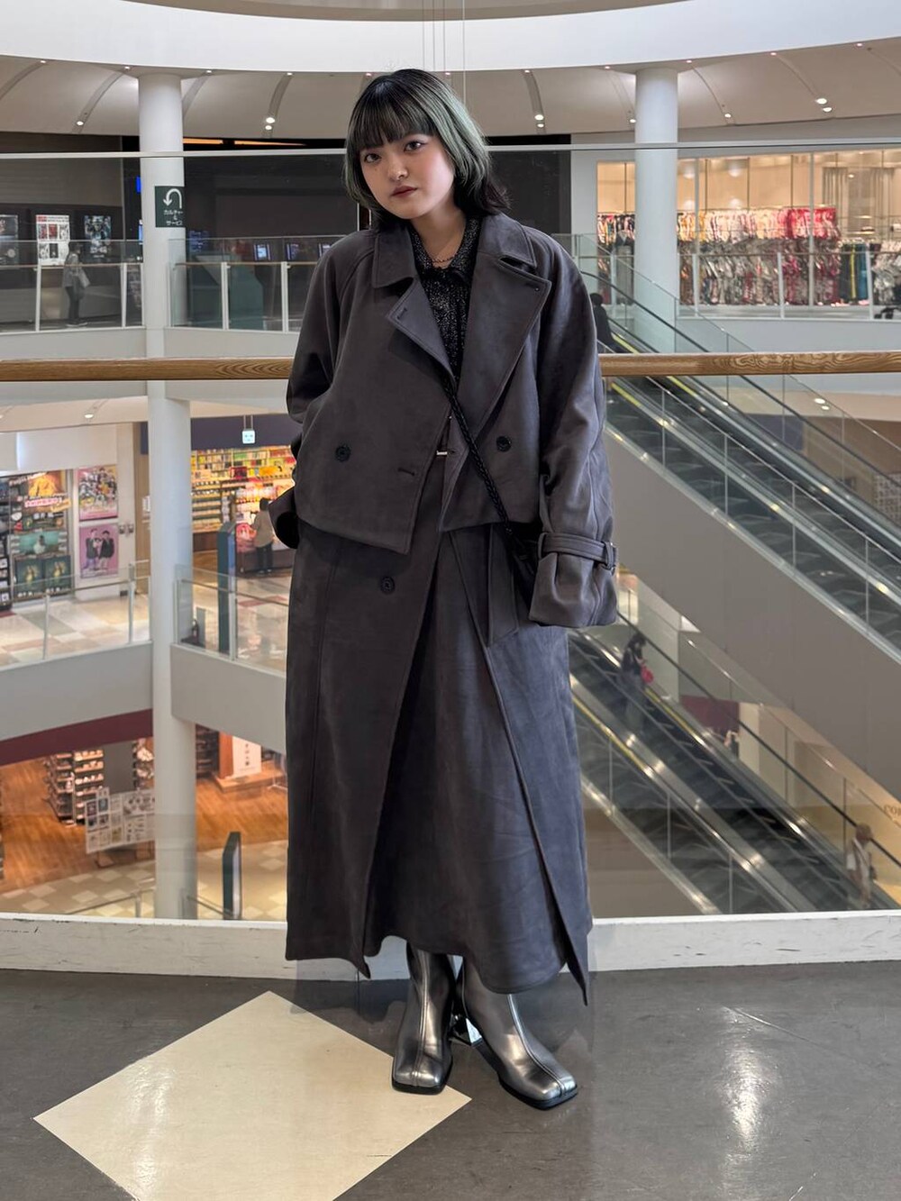シルバー系のブーツ、ブラック系のショルダーバッグ、ブラック系のカーディガン/ボレロを着用したレディースの秋コーディネートの4枚目の写真