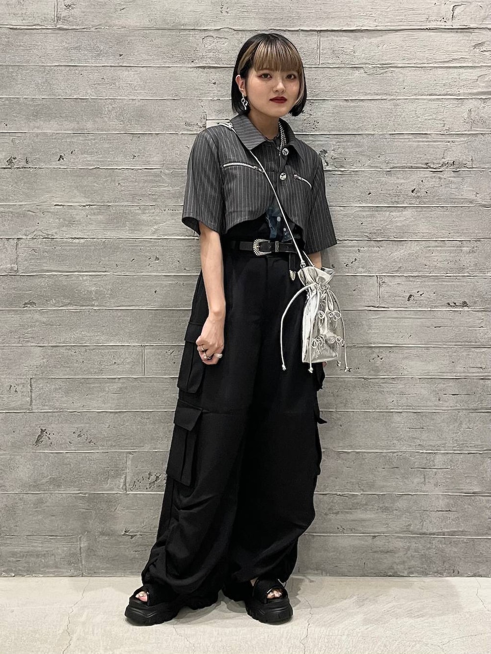 グレー系のタンクトップ、ブラック系のカーゴパンツ、グレー系のブルゾンを着用したレディースの夏コーディネートの2枚目の写真