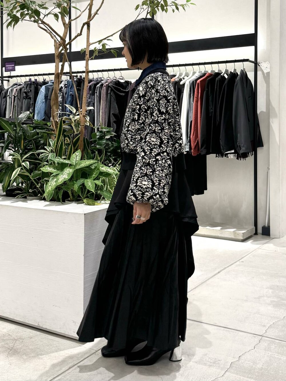 ブラック系のスカート、ブラック系のブーツ、ブラック系のニット/セーターを着用したレディースの秋コーディネートの3枚目の写真