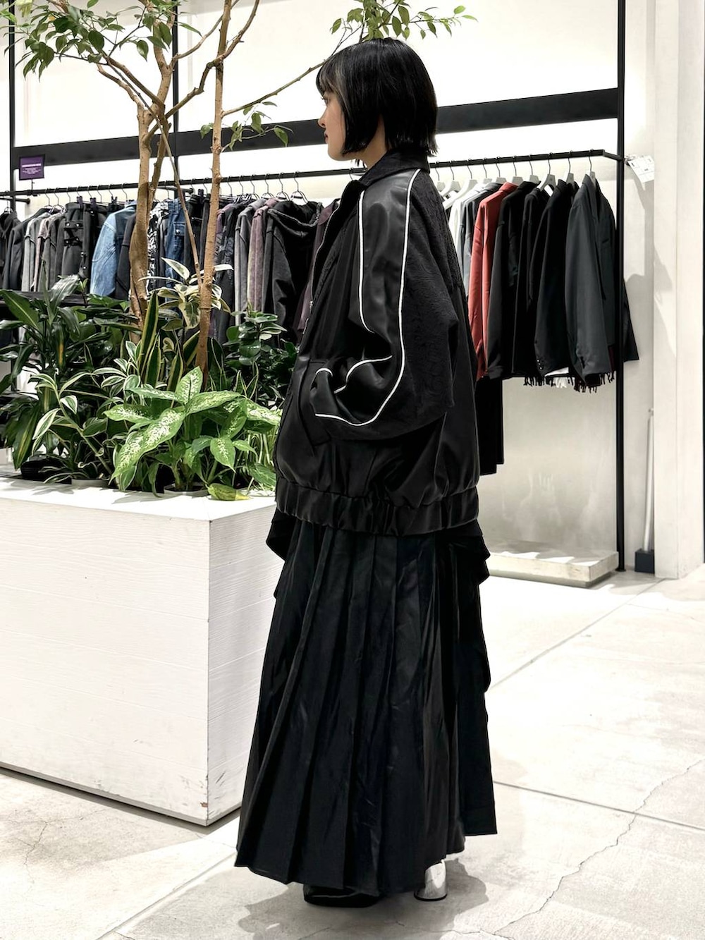 ブラック系のスカート、ブラック系のブーツ、ブルー系のシャツ/ブラウスを着用したレディースの秋コーディネートの2枚目の写真