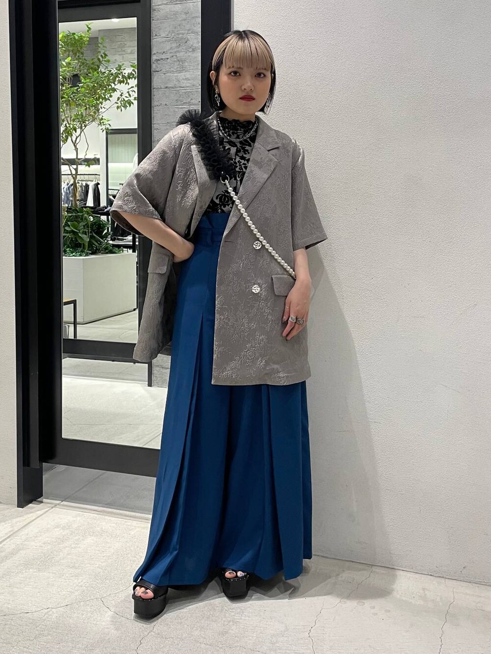 ブラック系のサンダル、ホワイト系のTシャツ/カットソー、ブルー系のその他パンツを着用したレディースの春コーディネートの2枚目の写真