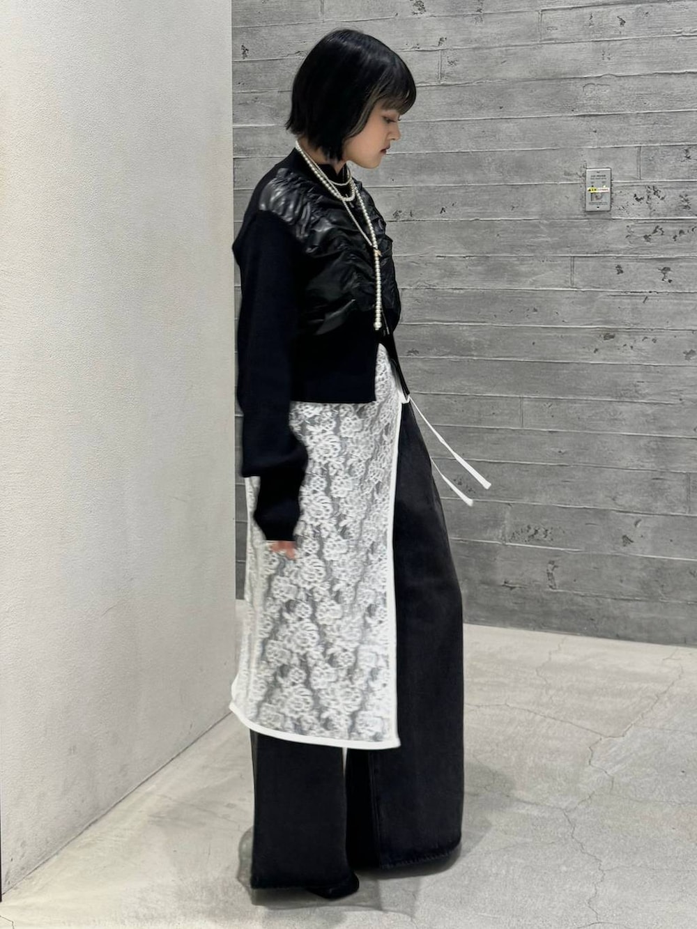 ブラック系のブーツ、ブラック系のデニムパンツ、ブラック系のニット/セーターを着用したレディースの秋コーディネートの3枚目の写真