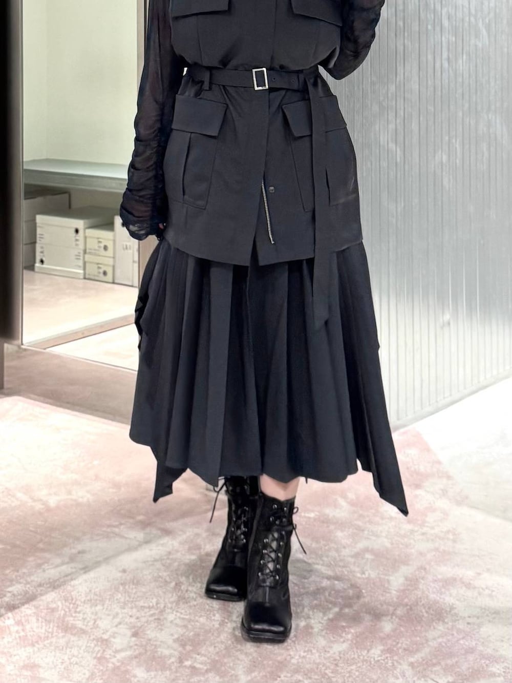 グレー系のスカート、ブラック系のブーツ、ブルー系のTシャツ/カットソーを着用したレディースの夏コーディネートの3枚目の写真