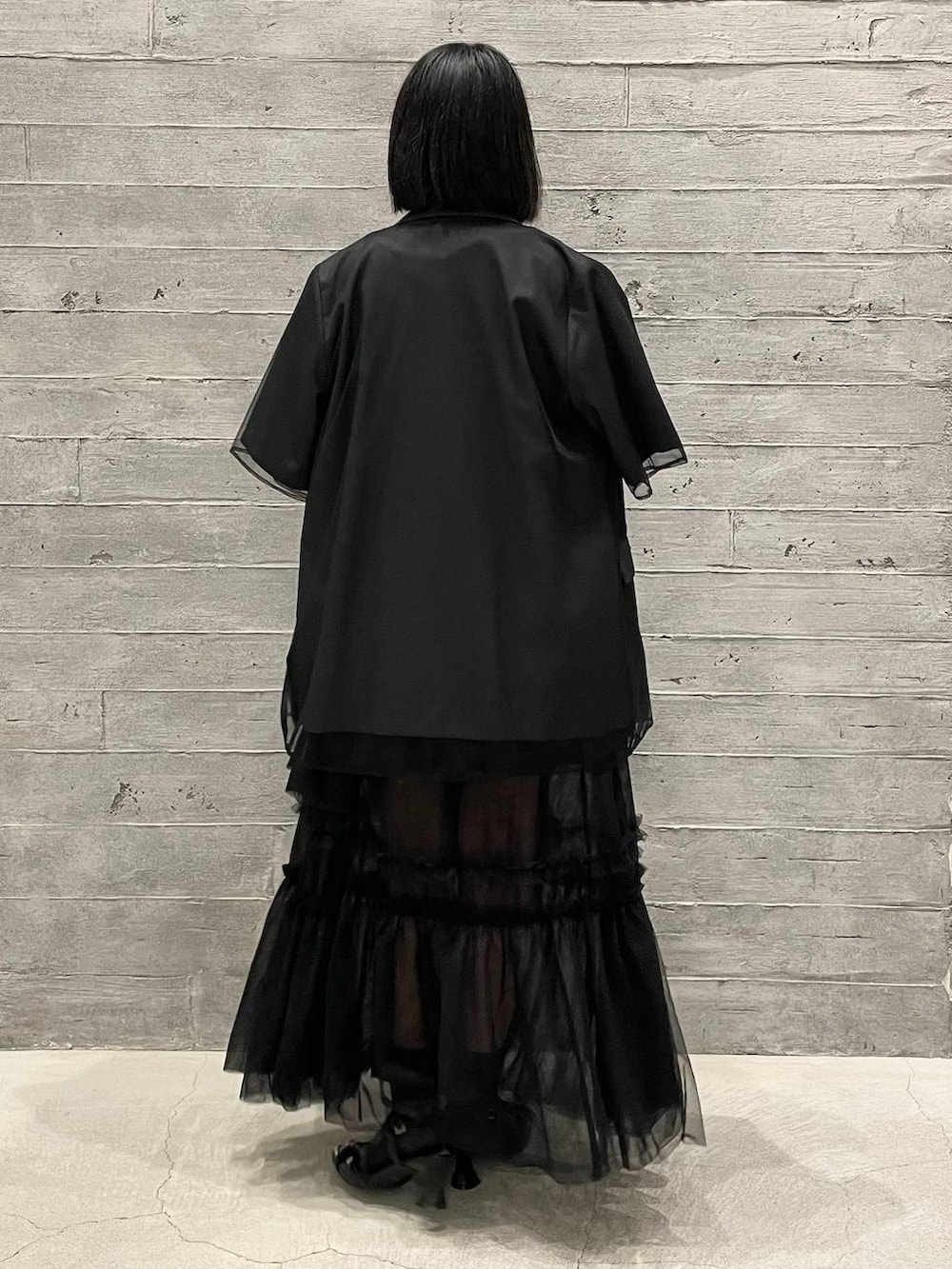 レッド系のニット/セーター、ブラック系のショルダーバッグ、ブラック系のパンプスを着用したレディースの夏コーディネートの5枚目の写真