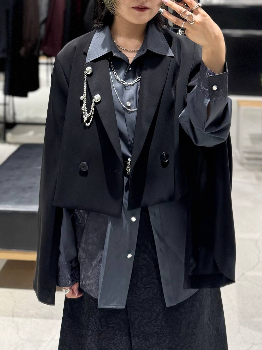 ブラック系のブーツ、ブラック系のテーラードジャケット、ブラック系のスカートを着用したレディースの秋コーディネートの3枚目の写真