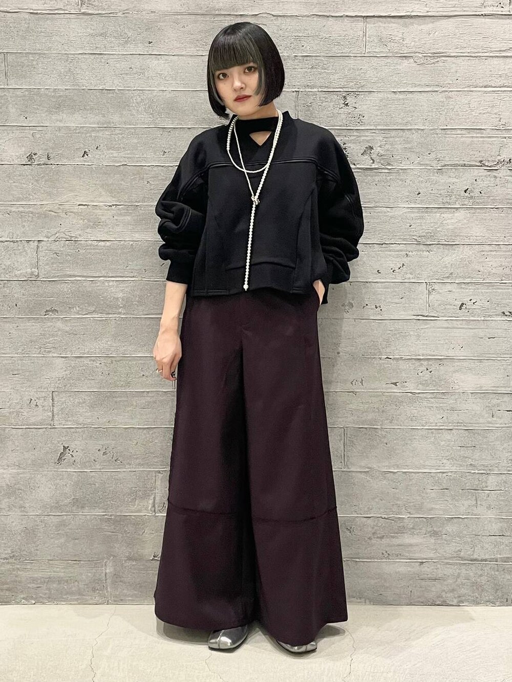 シルバー系のブーツ、ブラック系のスウェット、レッド系のその他パンツを着用したレディースの秋コーディネートの3枚目の写真