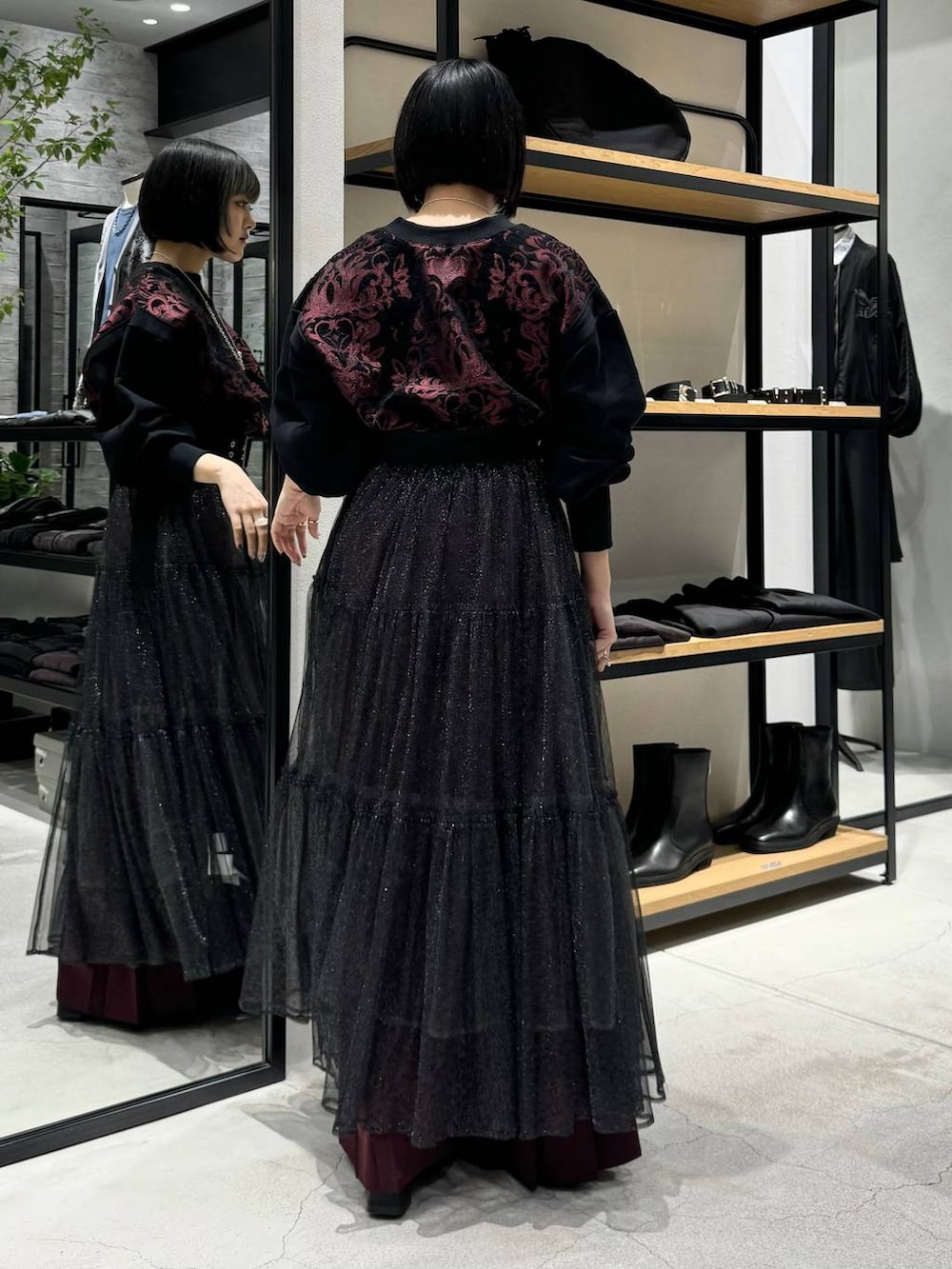 ブラック系のブーツ、レッド系のスウェット、レッド系のその他パンツを着用したレディースの秋コーディネートの4枚目の写真