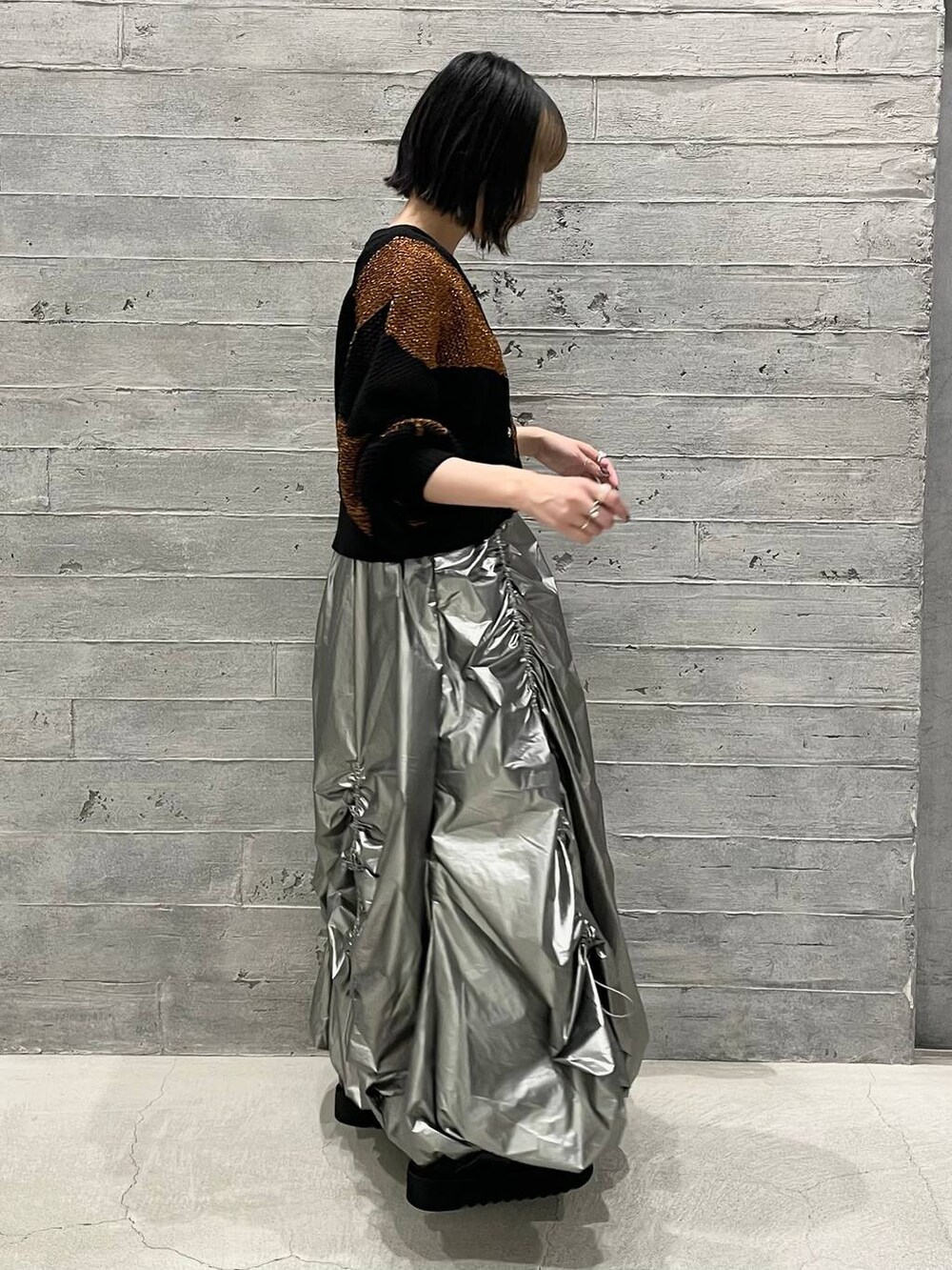 ブラック系のサンダル、オレンジ系のカーディガン/ボレロ、ブラック系のタンクトップを着用したレディースの夏コーディネートの4枚目の写真