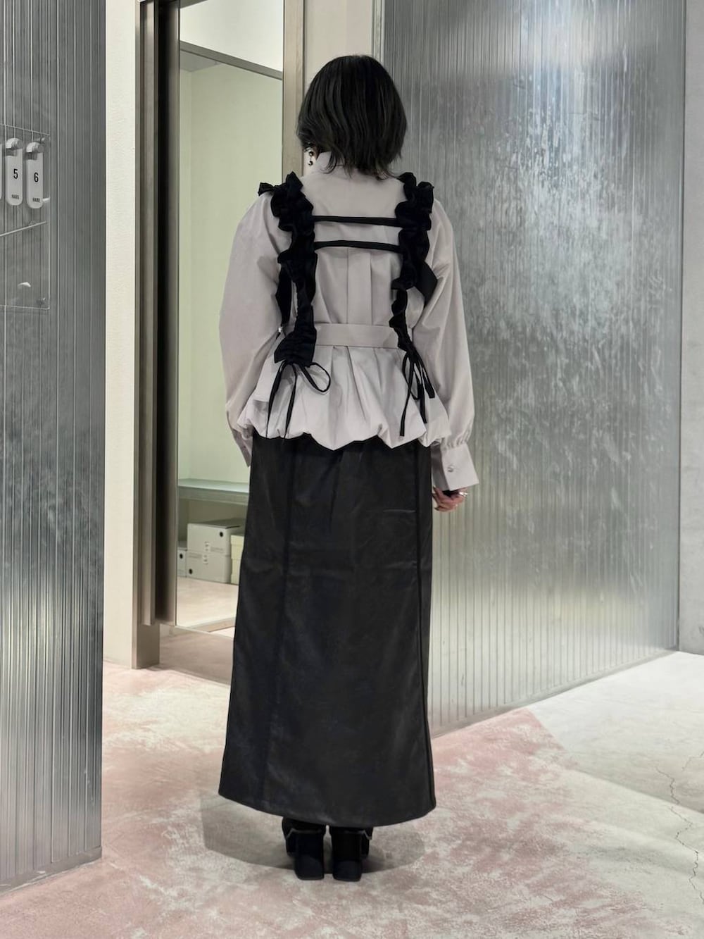 ホワイト系のシャツ/ブラウス、ブラック系のスカート、ブラック系のブーツを着用したレディースの秋コーディネートの5枚目の写真