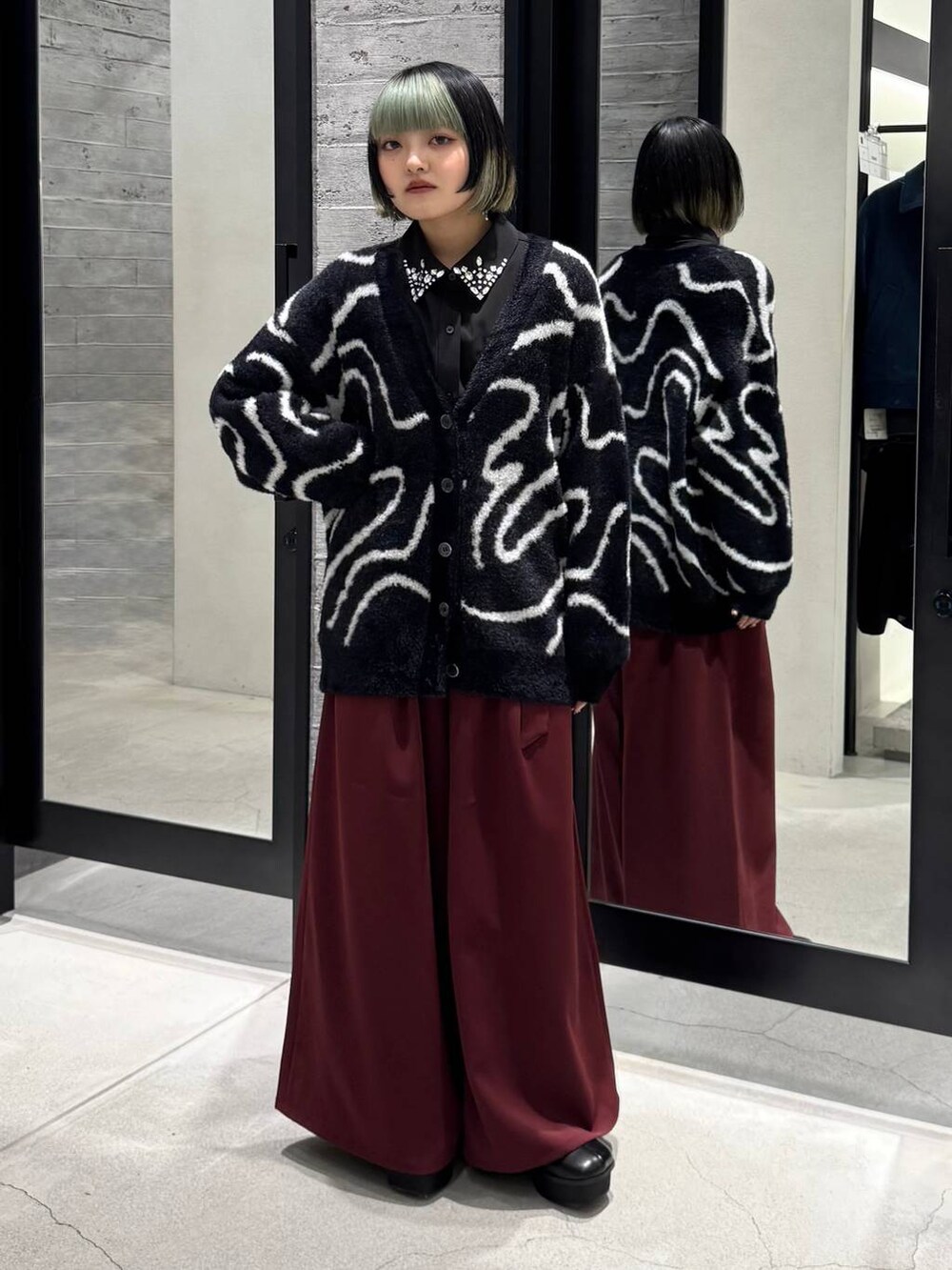 ブラック系のトレンチコート、ブラック系のシャツ/ブラウス、ブラック系のカーディガン/ボレロを着用したレディースの冬コーディネートの3枚目の写真